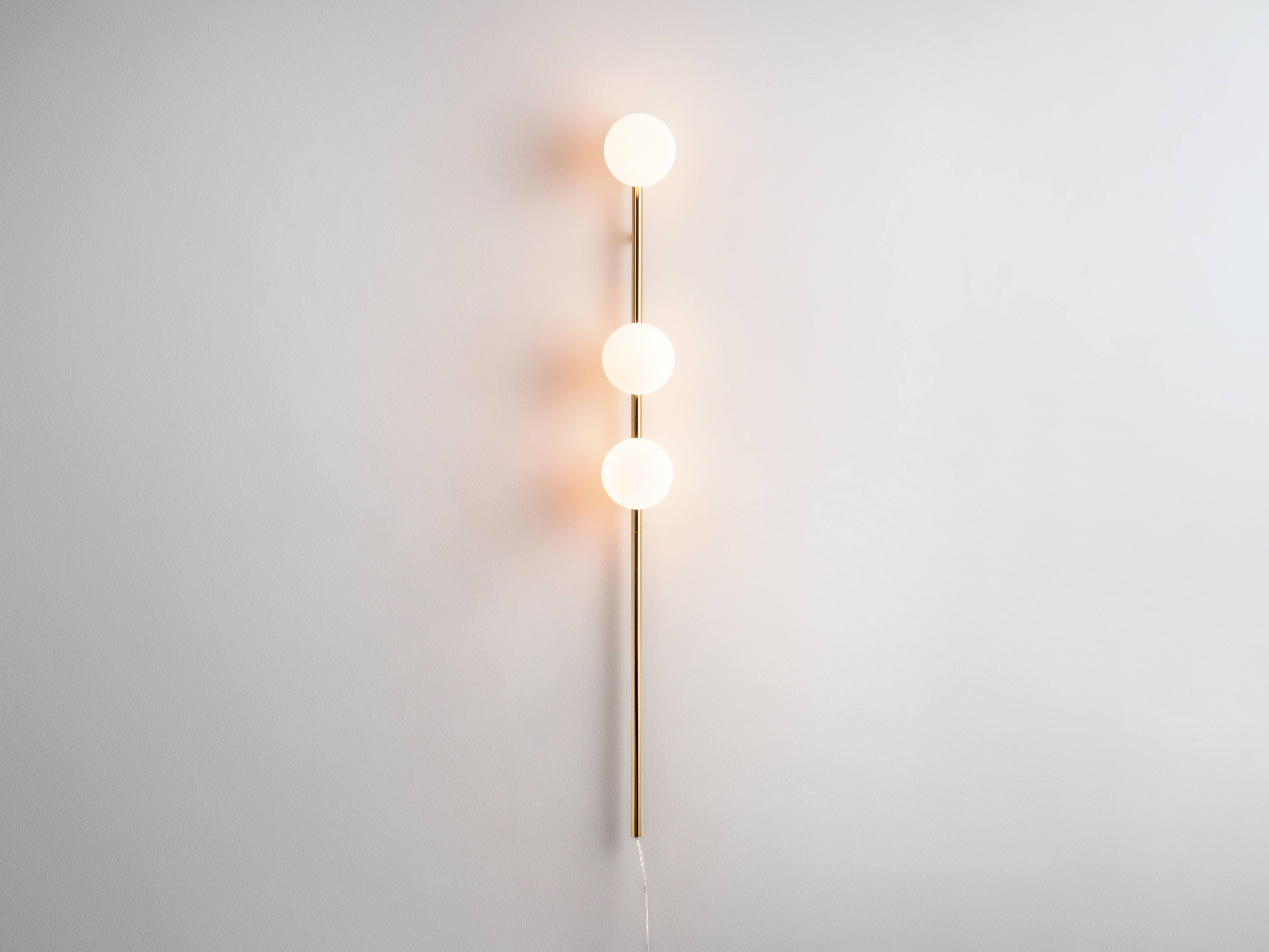 A perfect space saving light our bold polished brass bar opal ball wall light. With the power of a floor lamp but without the footprint, the metal bar holds three opal glass shades, which diffuse a soft, illuminating glow over your living spaces;