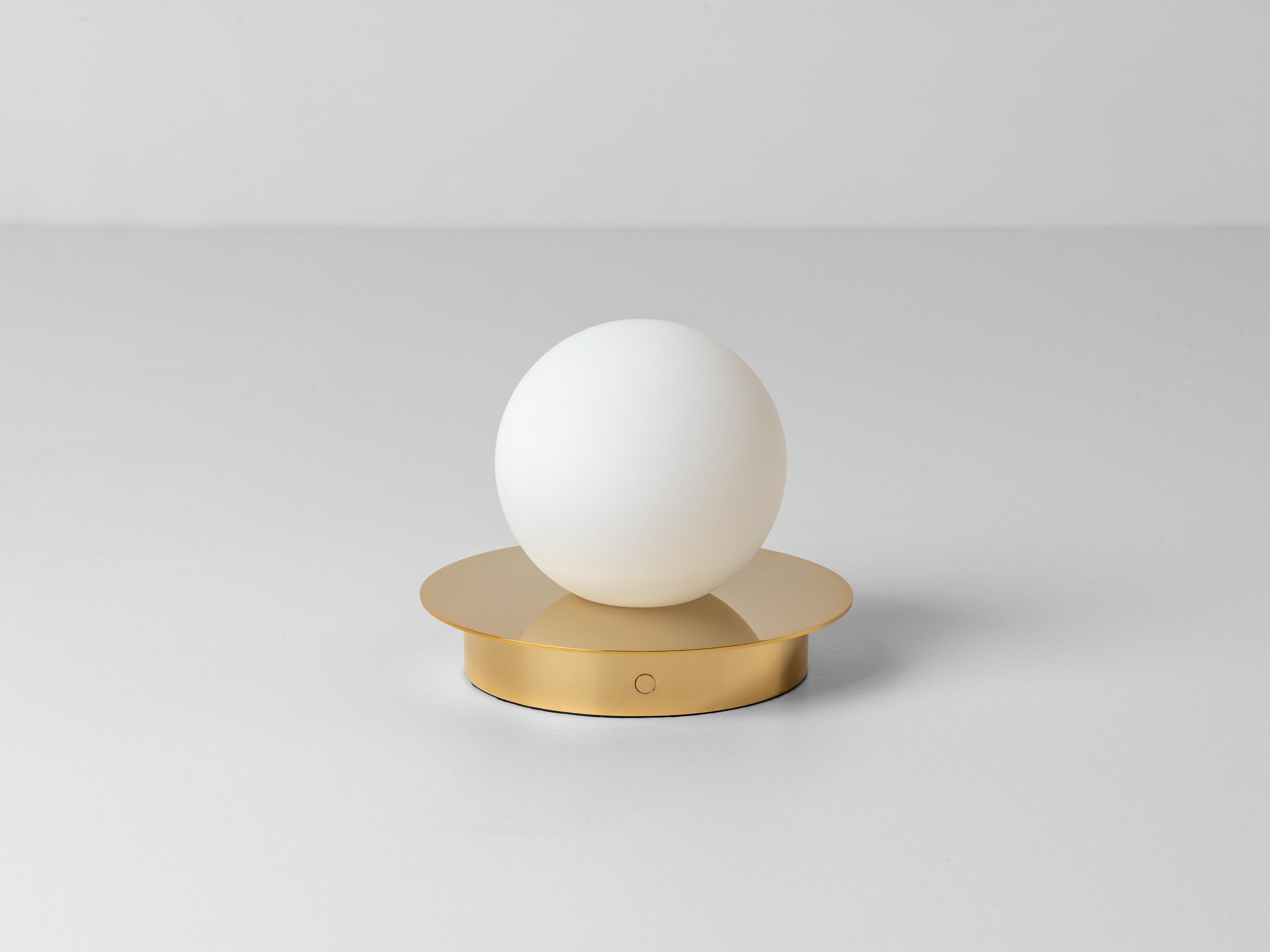 This cordless lamp is multi-functional; it can be moved from room to room as the perfect lighting solution. The disk mounted, opal glass shade, diffuses a warm illuminating glow. Ideal for a living space, bedroom or home office. Rich and opulent,