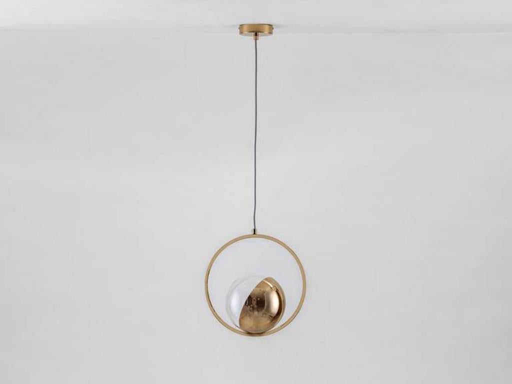 This unique modern ceiling light is designed to style in multiples. The adjustable metal ring ecases a large half plated glass globe, which diffuses a warm illuminating glow. Ideal for over a breakfast bar or dining table. Rich and opulent, Brass is