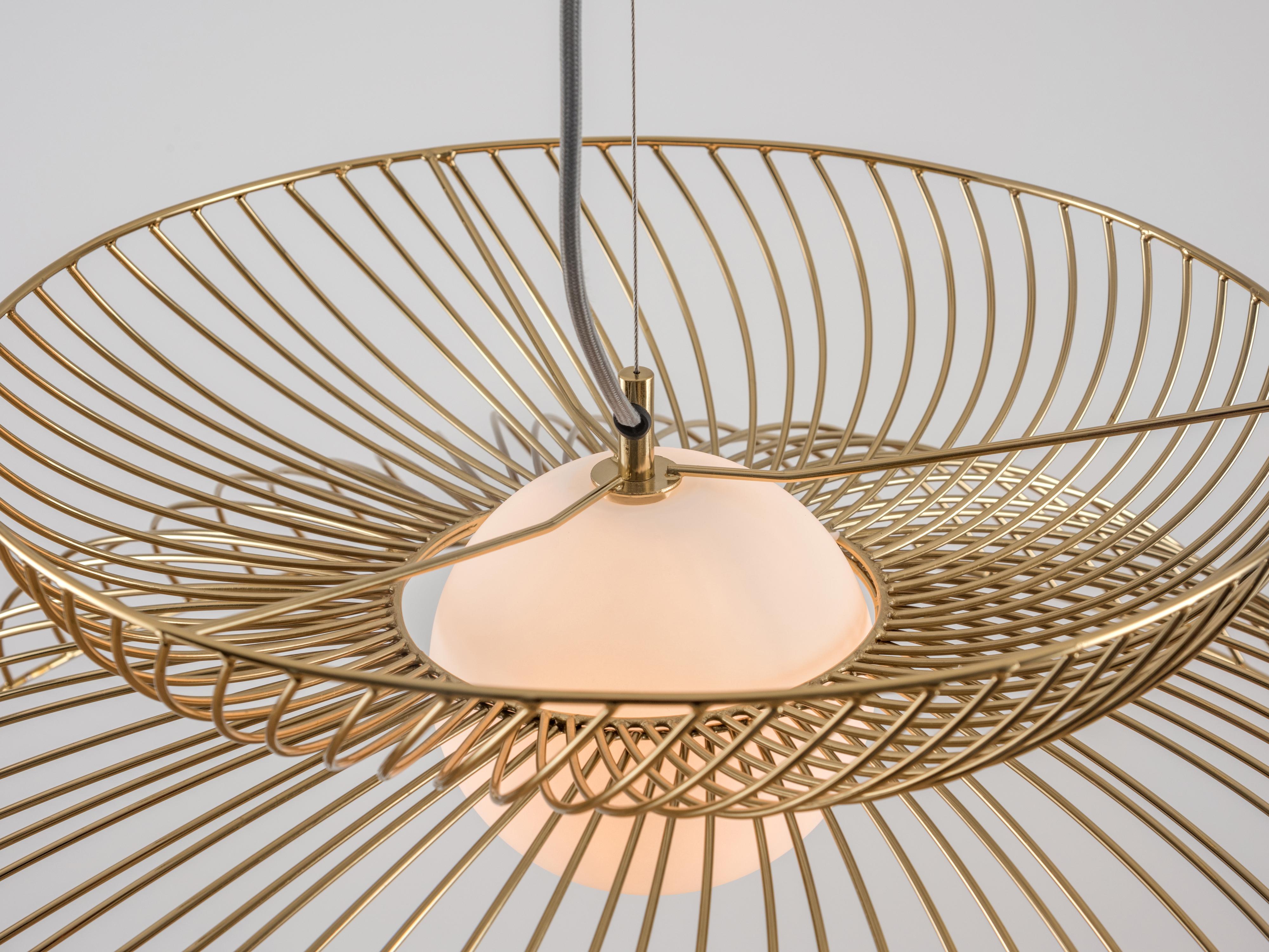 This bold statement light is perfect for a modern interior. The adjustable pendant wire suspends an opal glass shade and surrounding metal wire cage, which casts a wide atmospheric glow. Ideal for a dining space or room centrepiece. Or polished