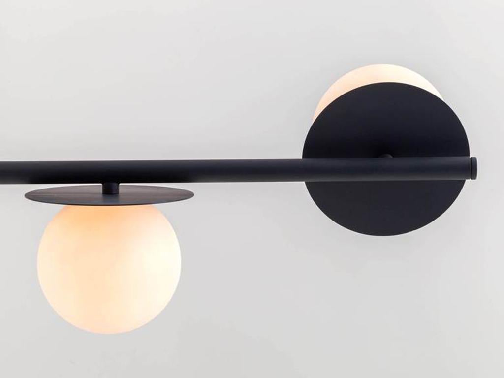 This modern ceiling light is adaptable for high and low ceilings. The elongated metal stem suspends four disk mounted, opal glass shades, which diffuse a warm illuminating glow. Ideal for a dining space or living room. Or pitch nearly black,