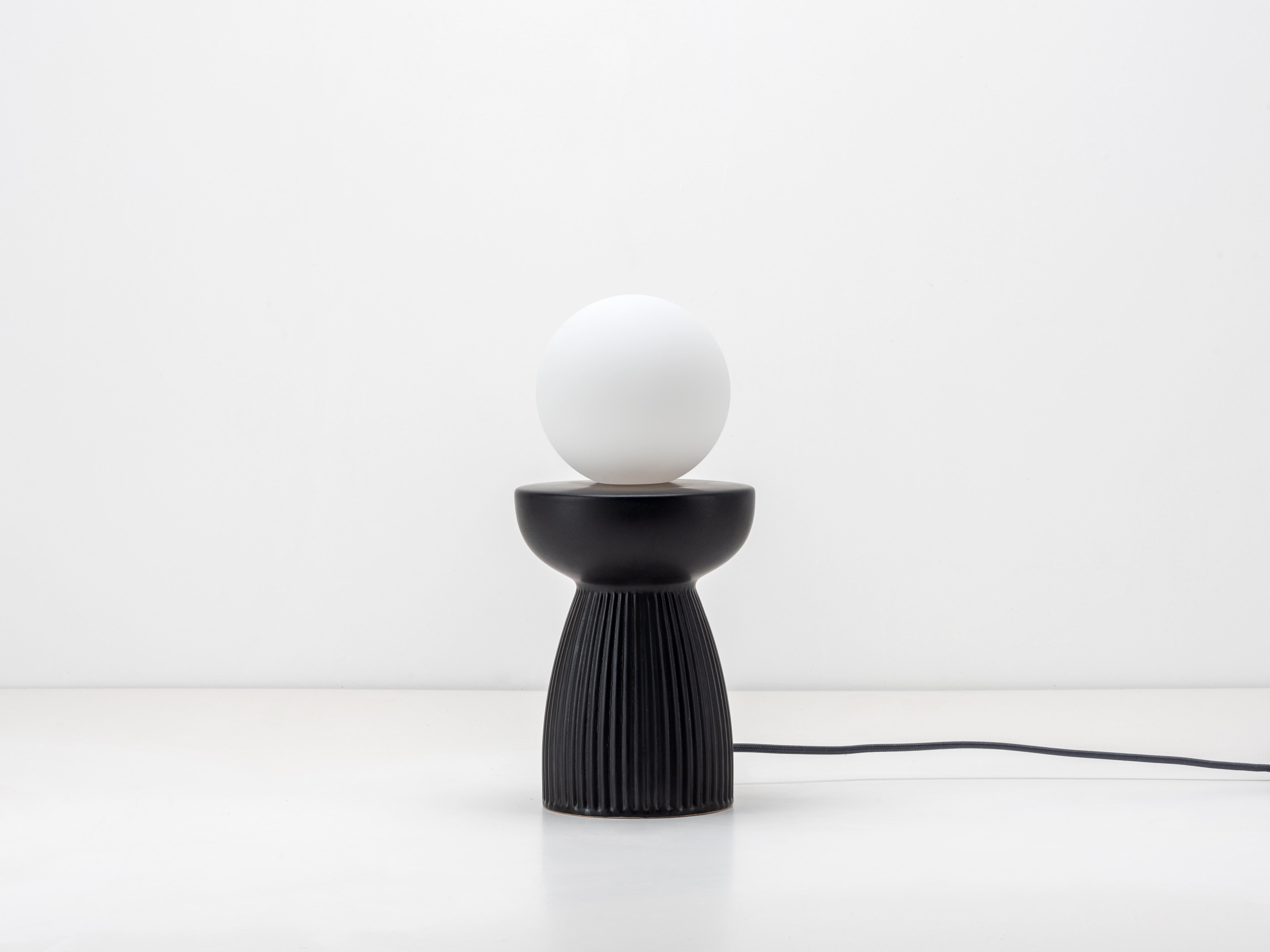 Inspired by nature, this lamp combines the tactile and cool ceramic finish with a ribbed form. Paired with our opal glass shade, it's the perfect calming light for any desk, side table or bedside. 2 year guarantee

Great lighting is about so much