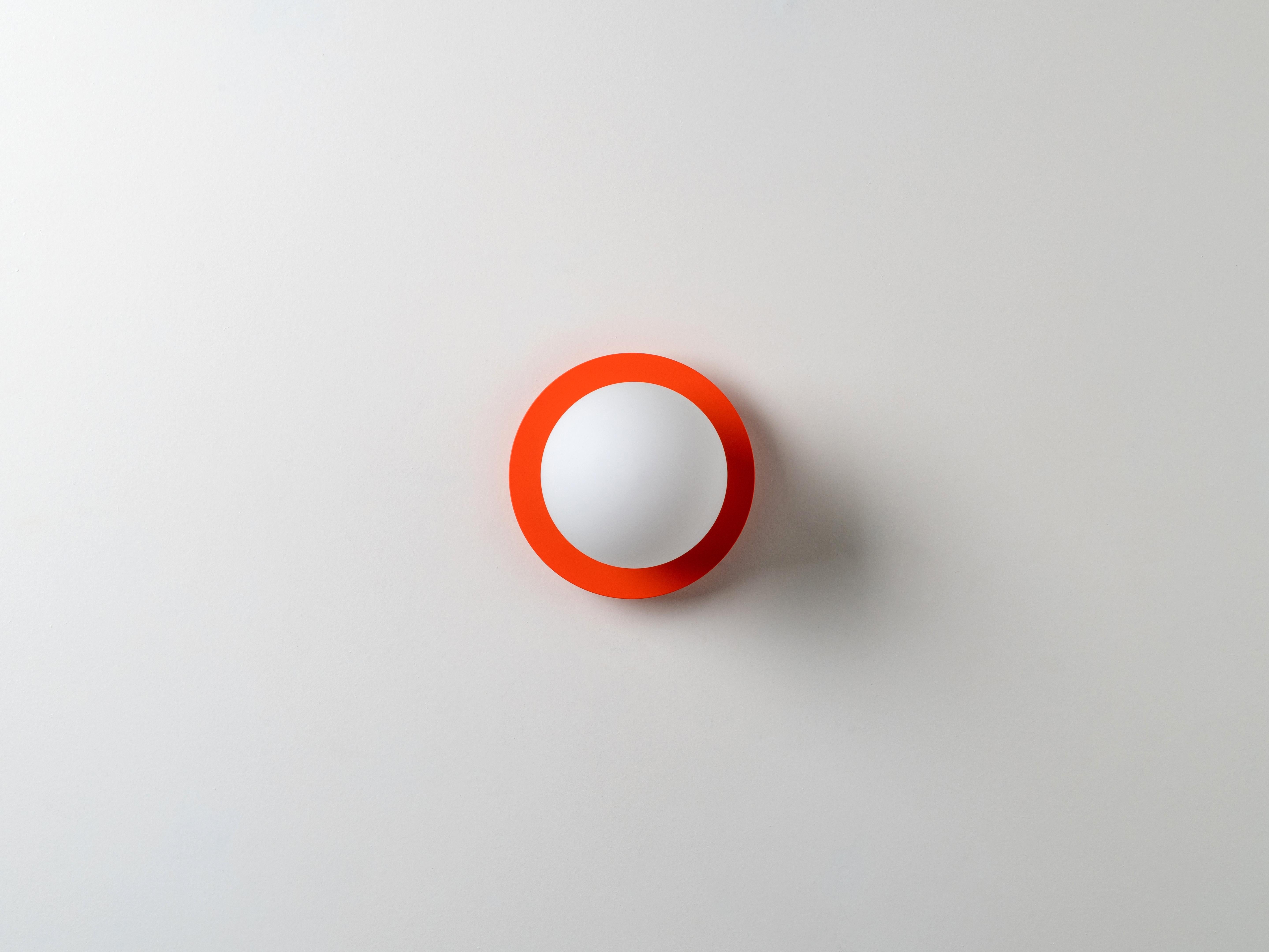 Cette applique moderne fonctionne partout. L'abat-jour en verre opalin monté sur disque diffuse une lumière chaude. Idéal pour un espace de vie, une cuisine, une chambre ou une salle de bain. L'orange fraîchement coupée et juteuse, qui met l'eau à