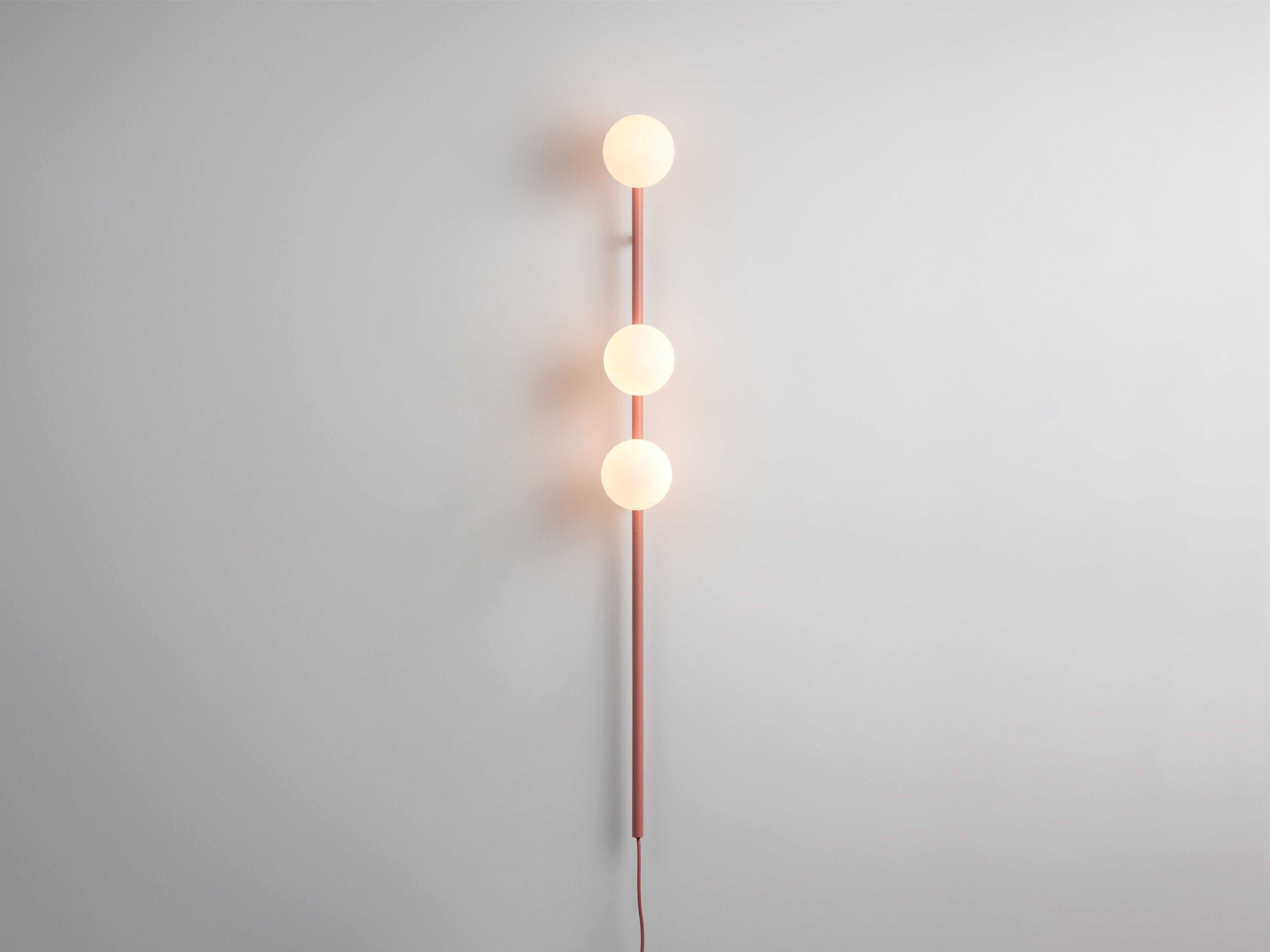 Una luz perfecta para ahorrar espacio nuestro atrevido aplique de bola opalina de color rosa suave. Con la potencia de una lámpara de pie pero sin ocupar espacio, la barra metálica sostiene tres pantallas de cristal opalino, que difunden un suave
