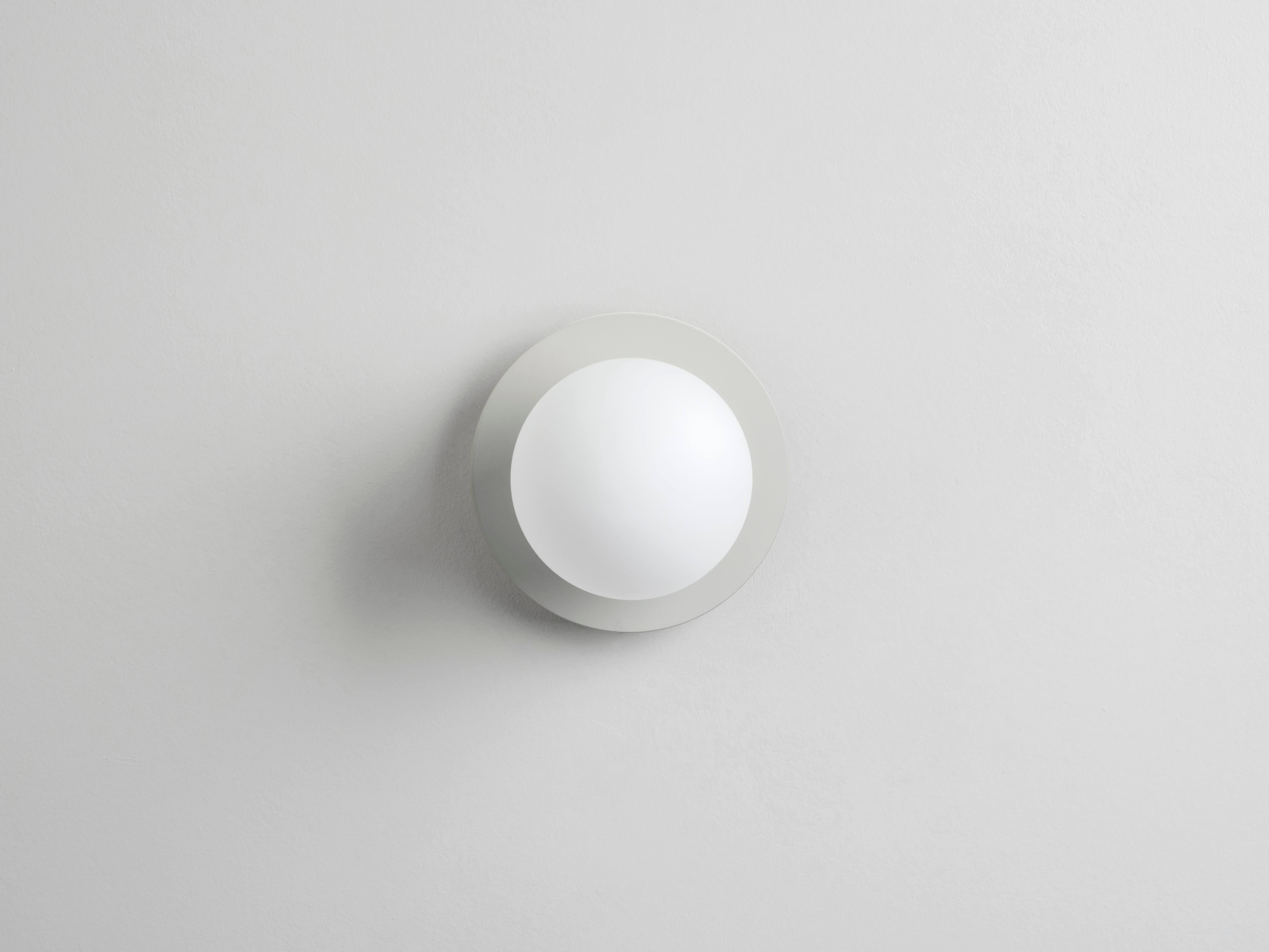 This modern wall light works everywhere. The disk mounted, opal glass shade, diffuses a warm illuminating glow. Ideal for a living space, kitchen, bedroom or bathroom. Or sand is the houseof staple that accentuates and emphasises. The soft block