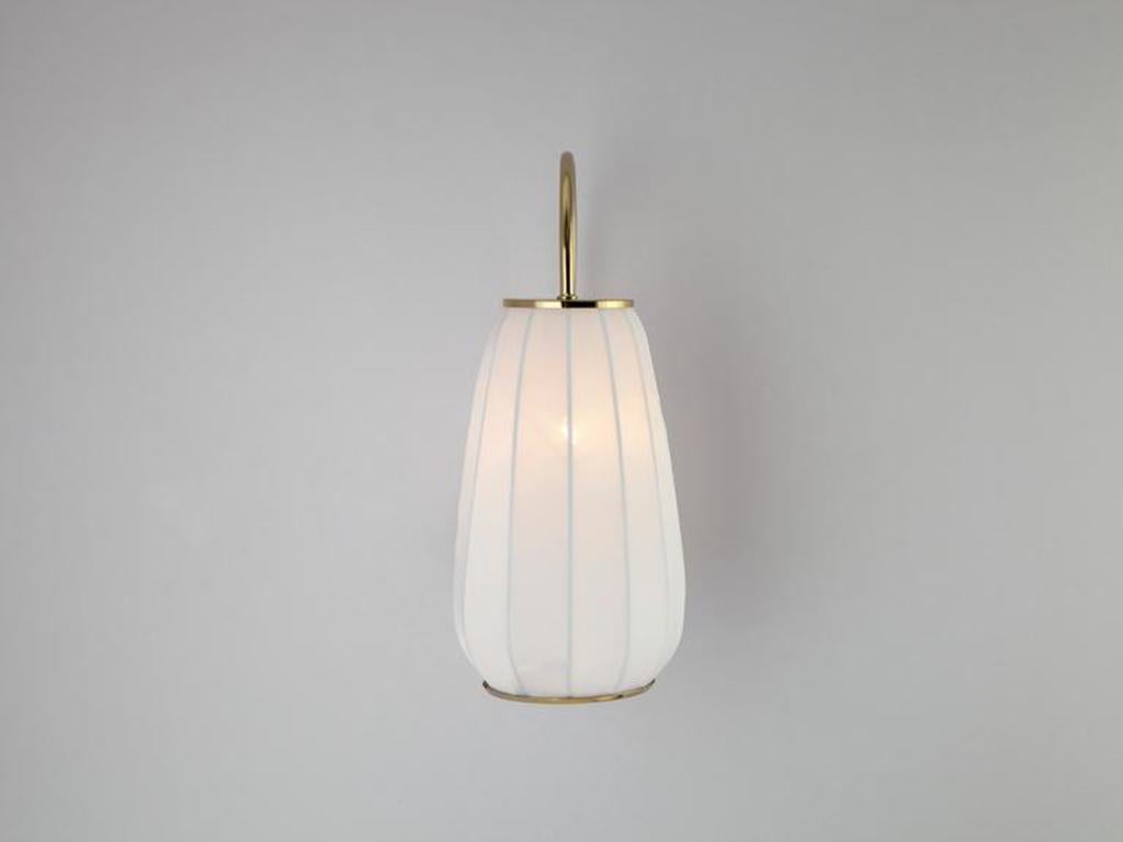 This simple wall light is an easy way to introduce soft lighting into your home. A white fabric shade, stretched over brass metal frame, diffuses a calming ambient glow. Ideal for a bedroom or dressing room. The colour of peace, calm and serenity,