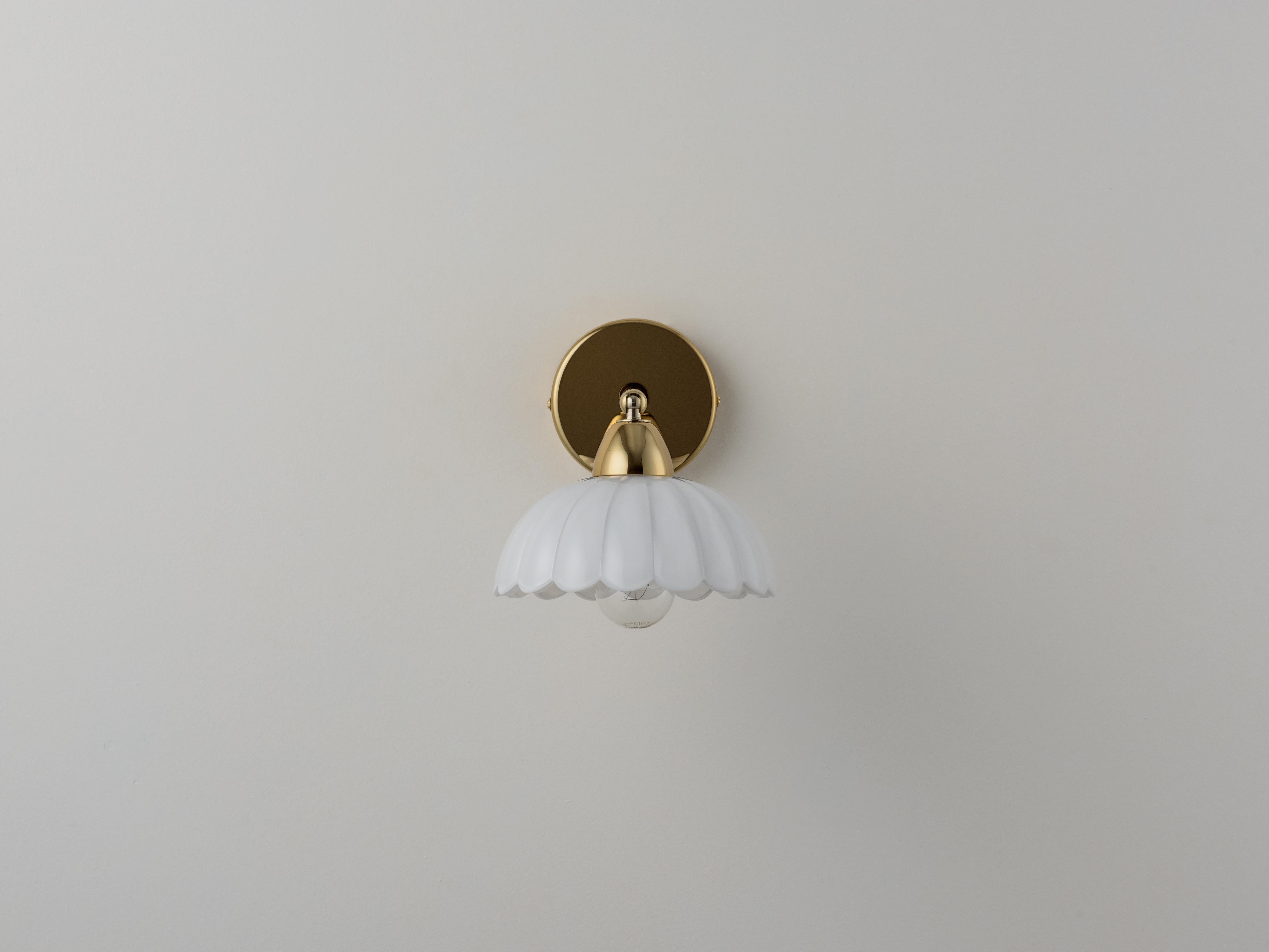 Ispirate al design degli anni '70, le forme floreali nostalgiche e giocose stanno diventando sinonimo di houseof. Questa lampada da parete ricorda le classiche brasserie francesi ed è dotata di un paralume mobile che consente di orientare la luce
