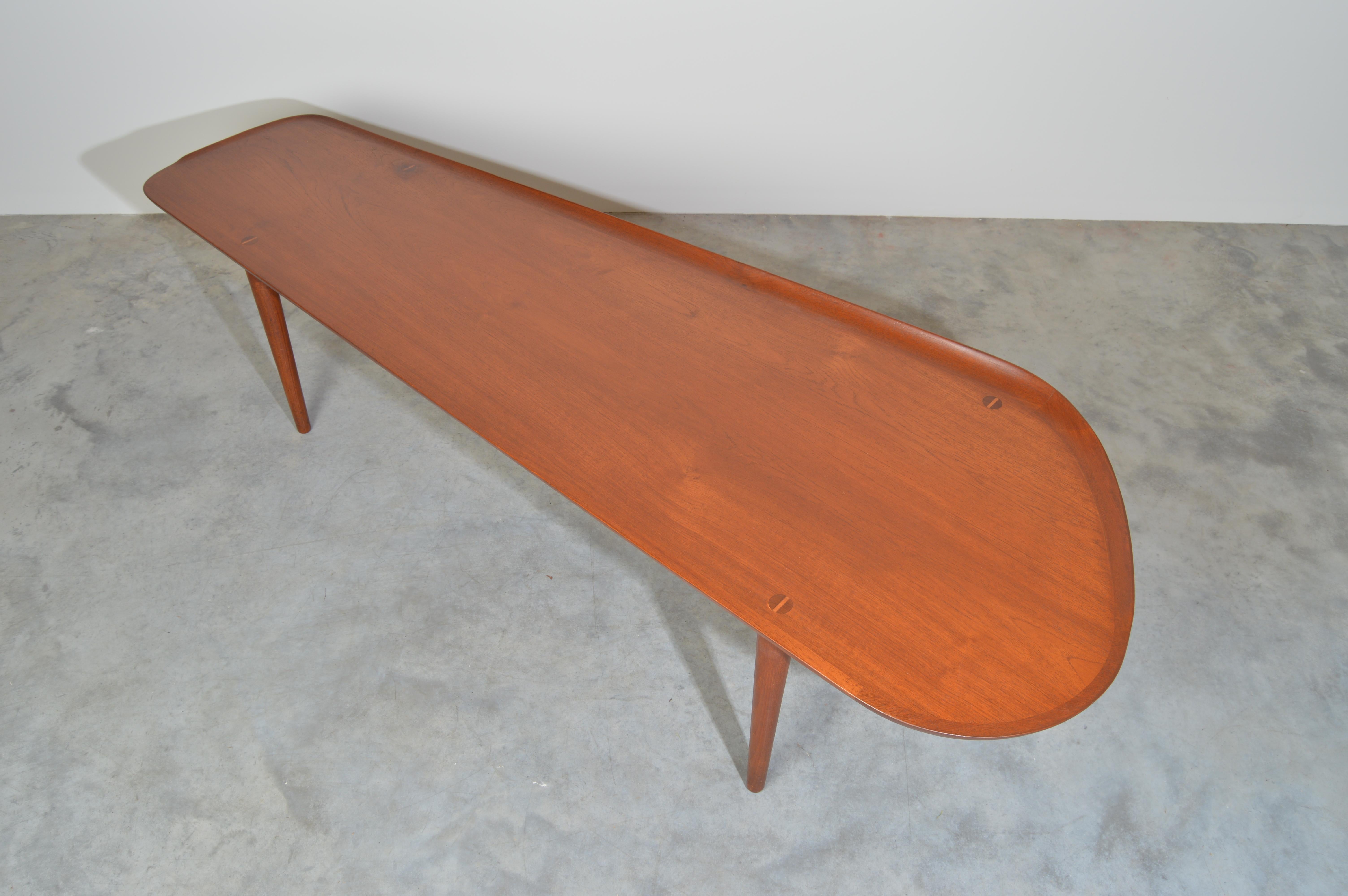 Long teak coffee table having a sculptural edge designed by Arne Hovmand-Olsen for Jutex.
Fabulous vintage condition. Professionally cleaned and finished. Signed with foil label underneath.
Measures: Length 6’ widest width 24.5” narrow width