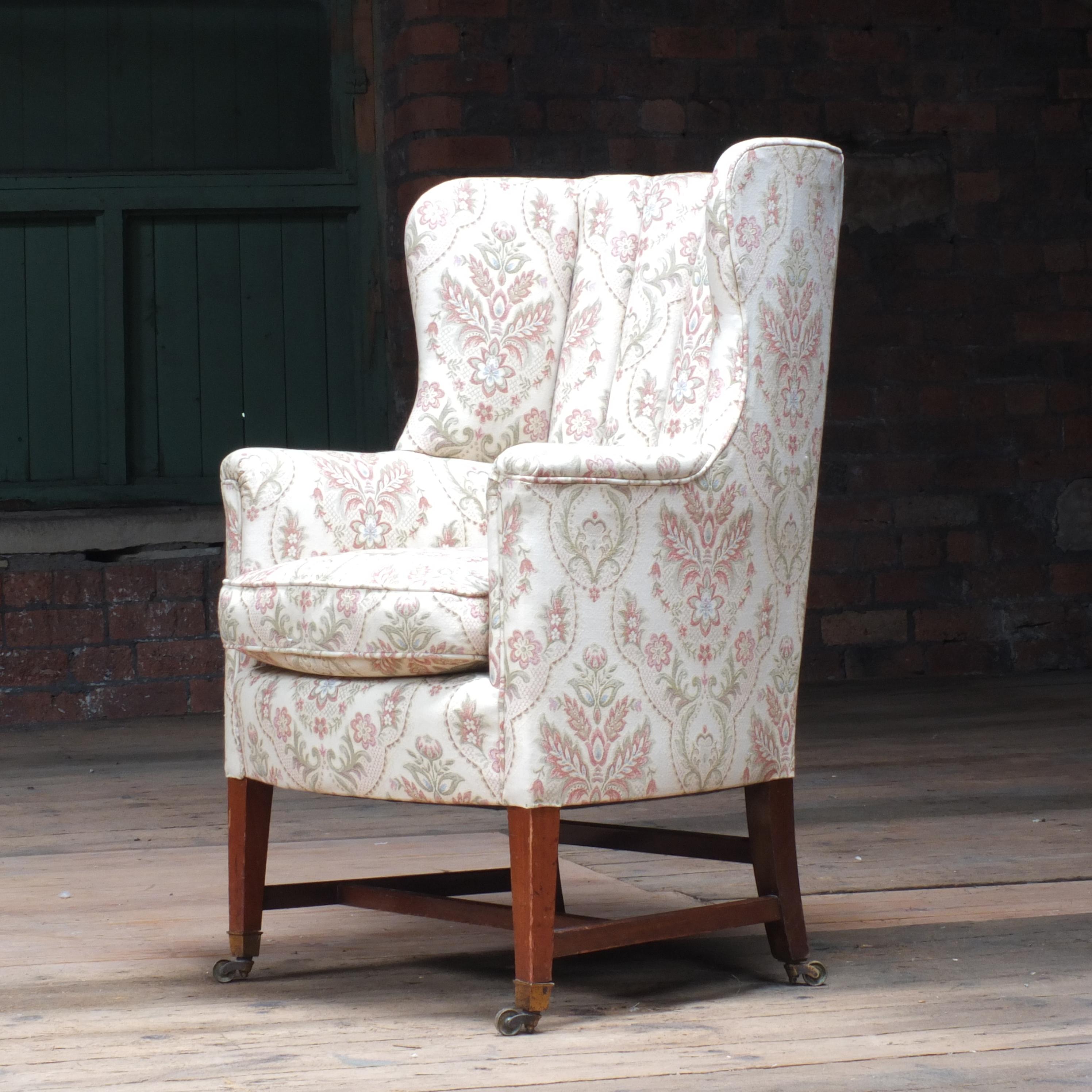 An elegantly formed Howard and Sons barrel back armchair raised on mahogany supports with front cup casters and the back both stamped H&S. The back left leg stamped 