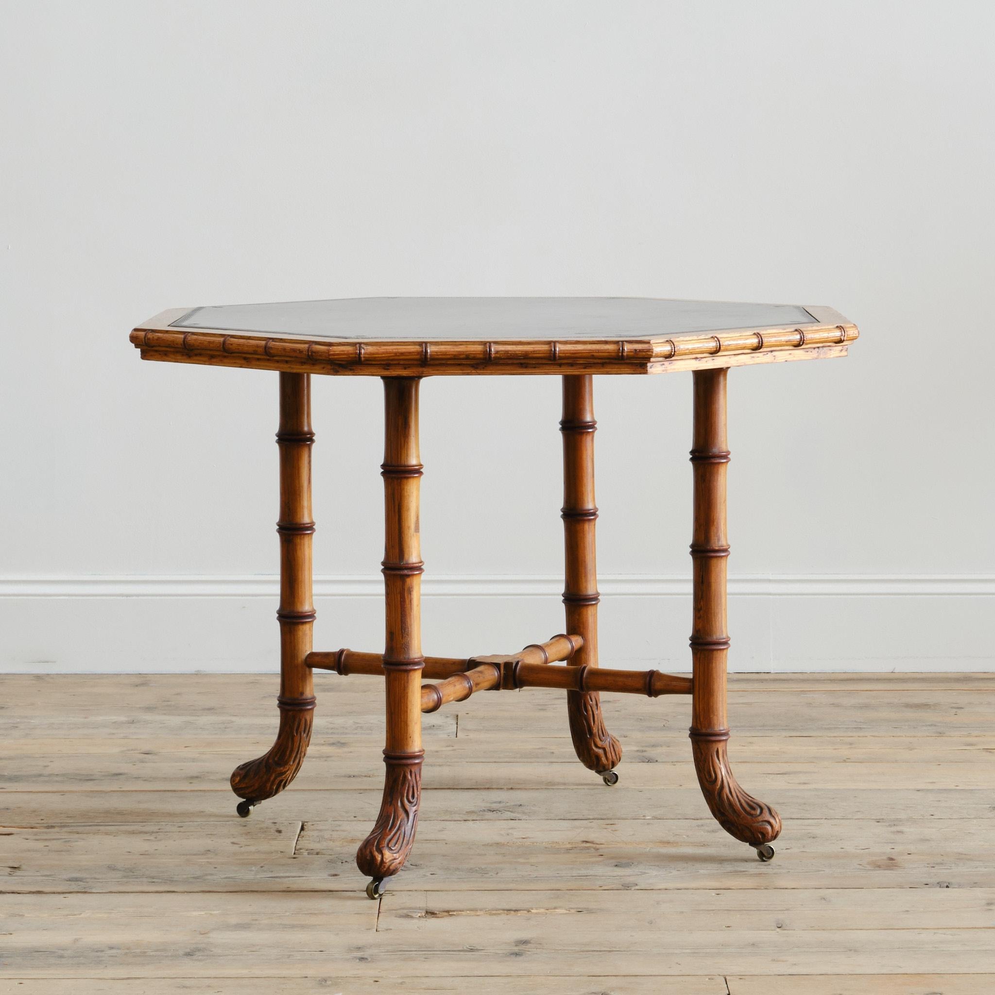 A wonderful 19th century Howard and sons Oregon pine Centre or side table. Raised on turned faux bamboo supports and stretchers with the original painted decoration. The supports capped with faux bois feet and the original brass Copes Casters. The