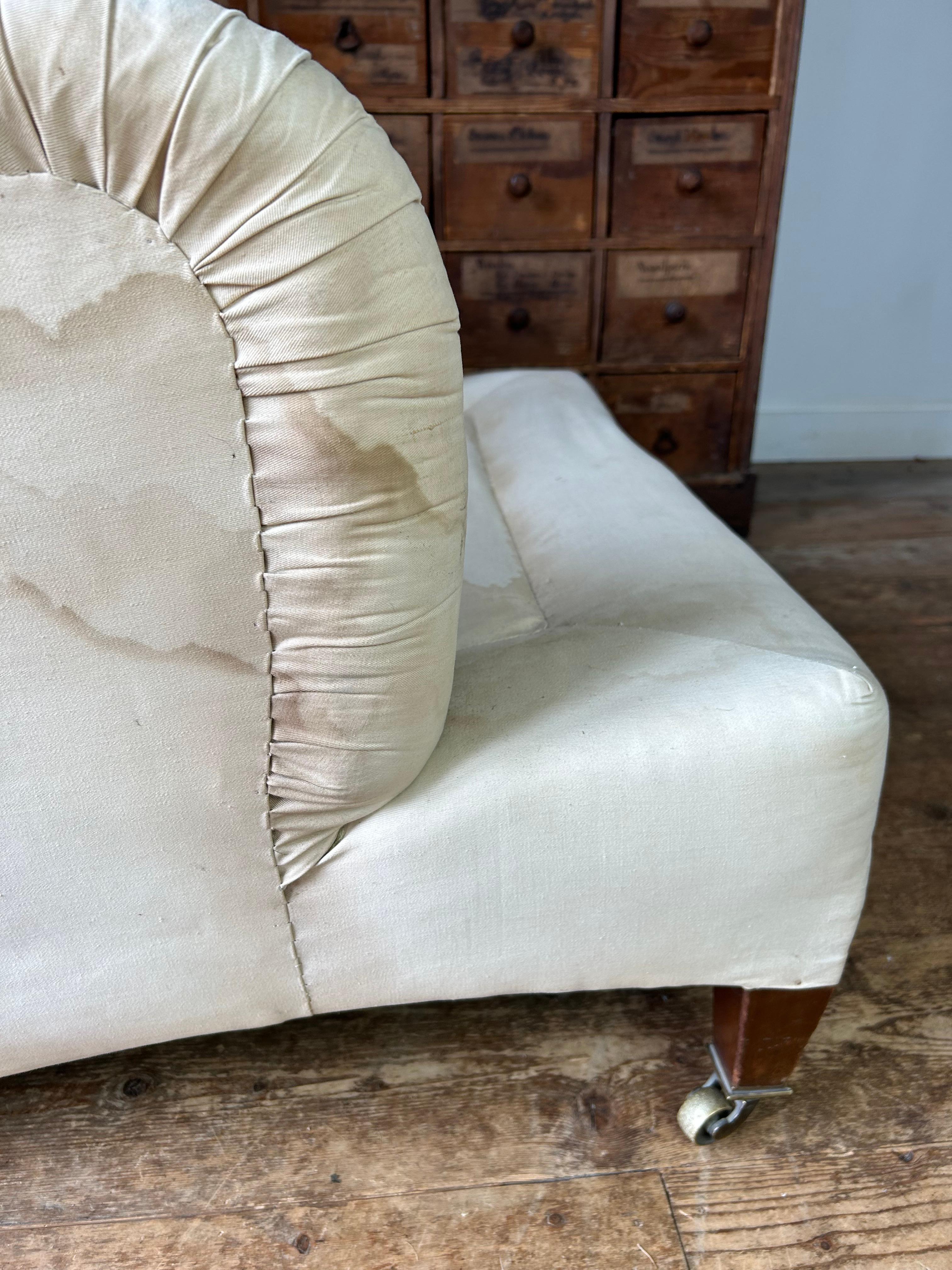 La poltrona modello Ivor di Howard and Sons è la più rara e ricercata, essendo di proporzioni molto generose. Conserva la tappezzeria originale in calico e il cuscino in piuma e piumino. Questa poltrona estremamente confortevole presenta una