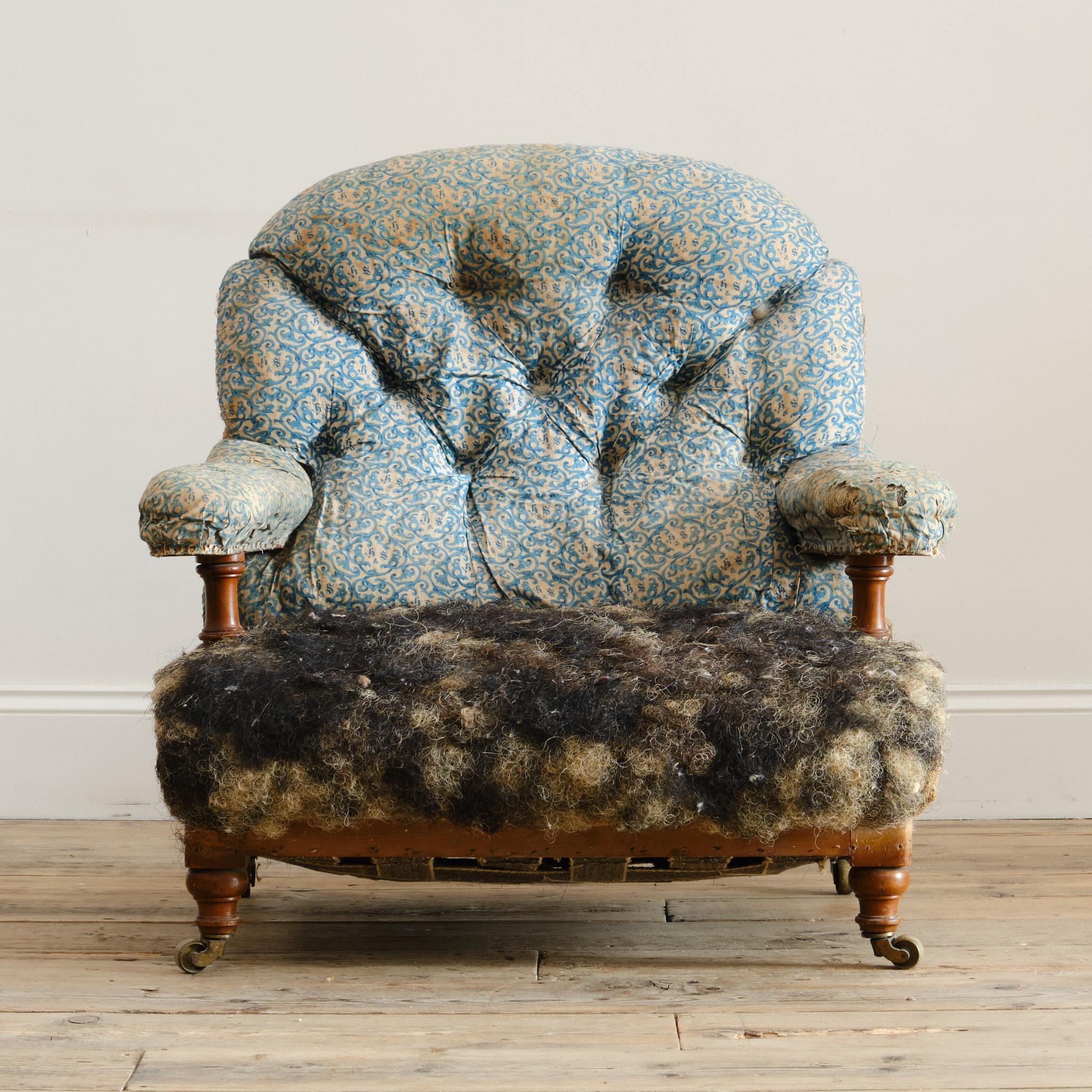 A mid 19th century open back armchair by Howard & Sons - London. Raised on turned walnut front legs and arm supports with splayed rear legs and all with the original Cope & Collinson brass casters. C1840 

Provenance. Powderham Castle, Devon -