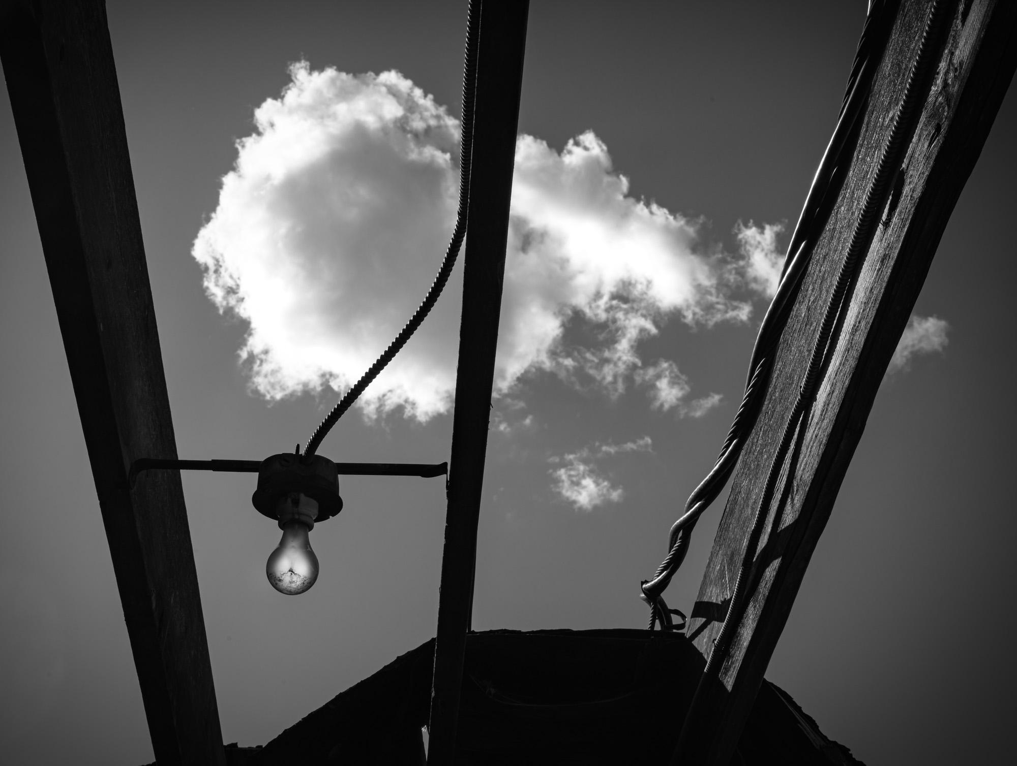 Limited Edition Black and White Photograph, Bulb and Cloud 2021. I enjoy exploring abandoned buildings and this one was ripe for a Sunday afternoon with a perfect cloud to get the right composition.

About:
Lewis’ artistic practice often explores