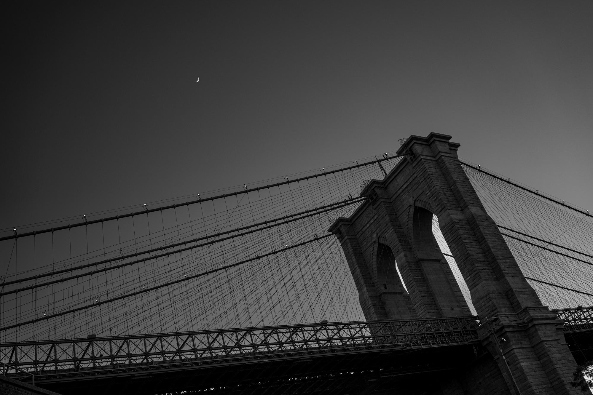   Limited Edition Black and White Photograph - Moon over Brooklyn, 2022. Taken in the NYC borough of Brooklyn at the base of the Brooklyn Bridge.

About Howard Lewis:
Lewis’ artistic practice often explores science, engineering, technology, and