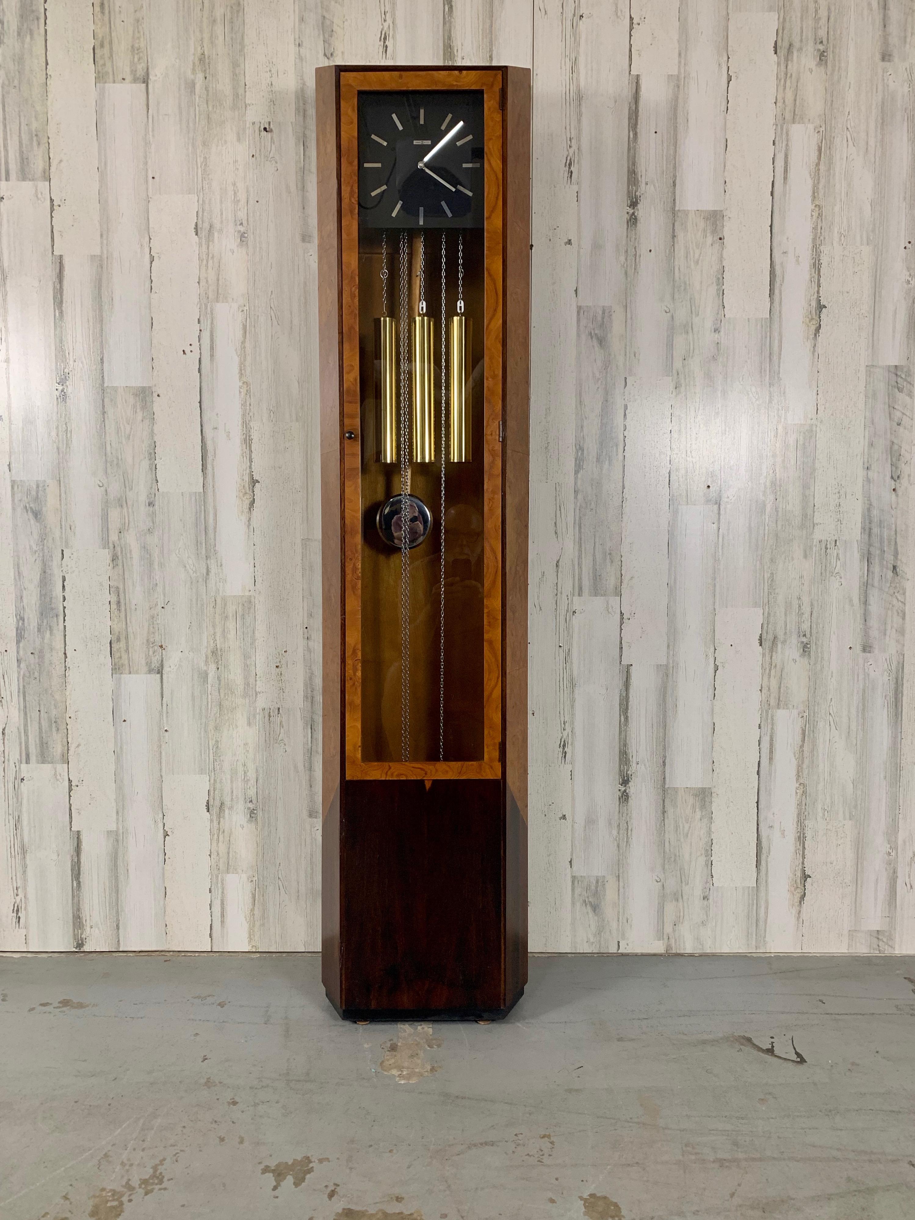 Stunning Burl wood with rosewood grandfather clock by Howard Miller clock company. This will run for eight days on a single wind. Nice combination of chrome and brass with exotic wood and westminster chimes that strike on the quarter hour as well as