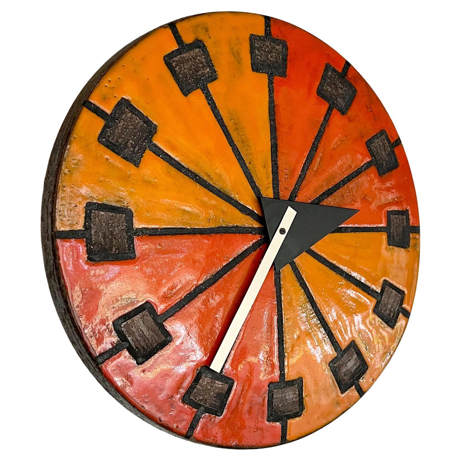 Howard Miller Meridian clock in shades of red/orange and golden yellow glazes over chamotte clay body, circa 1960s. Clock measures 14