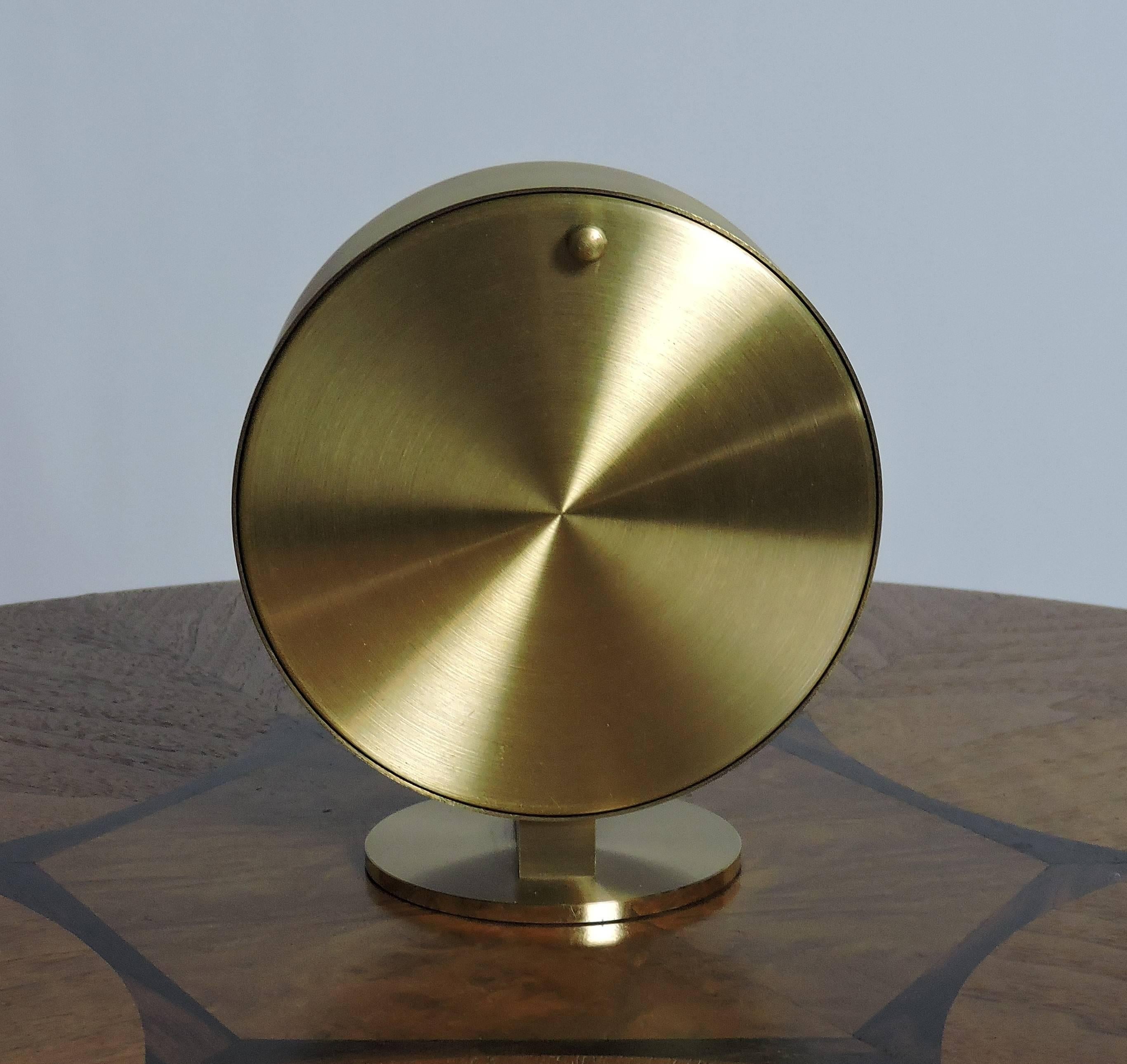 Handsome Mid-Century Modern Minimalist style desk clock based on a 1940 design by Nathan George Horwitt and manufactured by Howard Miller. This clock has a round black dial, a brass housing and brass details. Classic and timeless design, it takes a