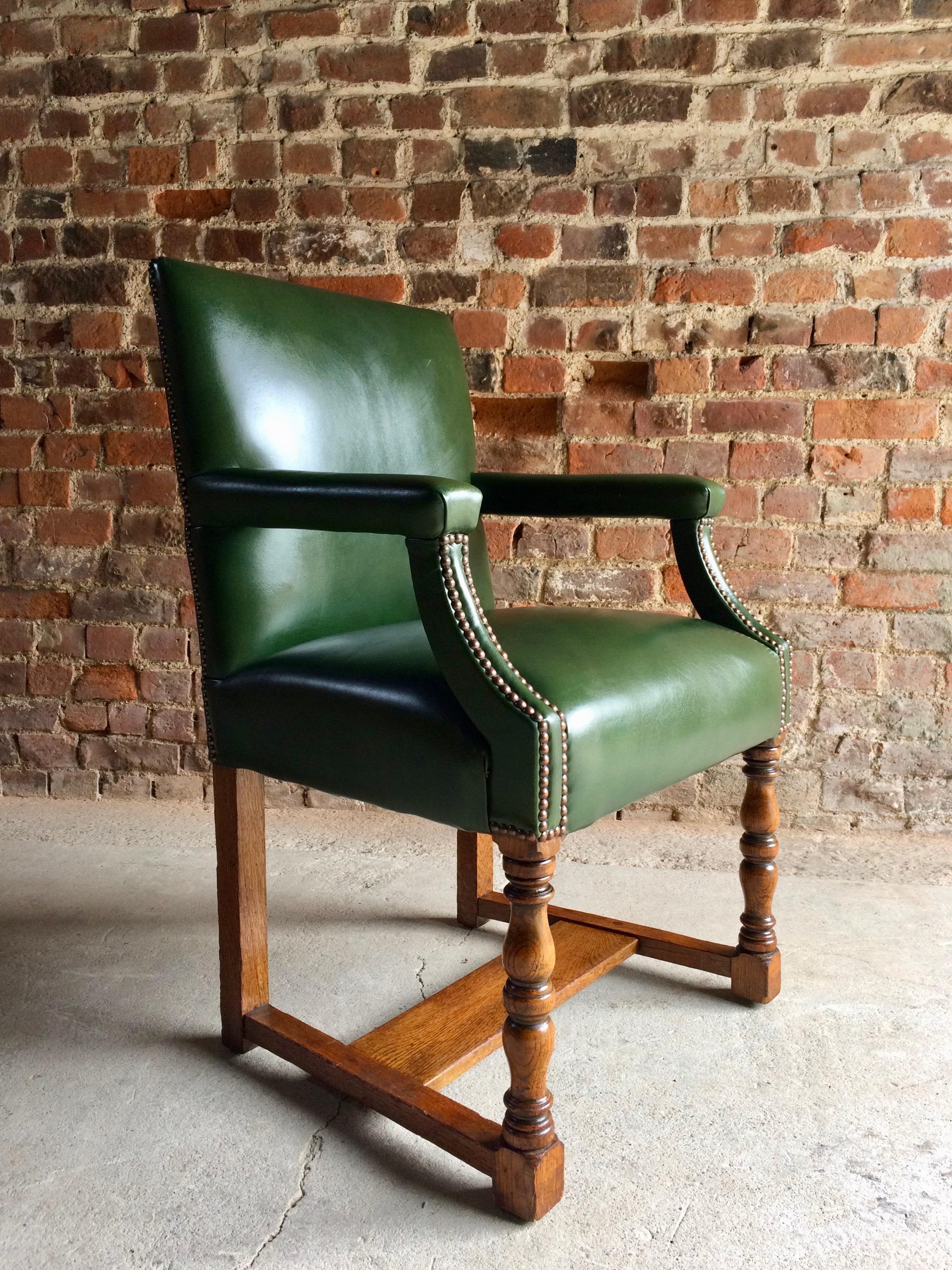 Howard & Sons solid oak Gainsborough library or boardroom chairs dating to circa 1890, the chairs have recently been re upholstered in the finest deep bottle green leather with brass stud bound work, raised on turned legs, joined by H stretcher,