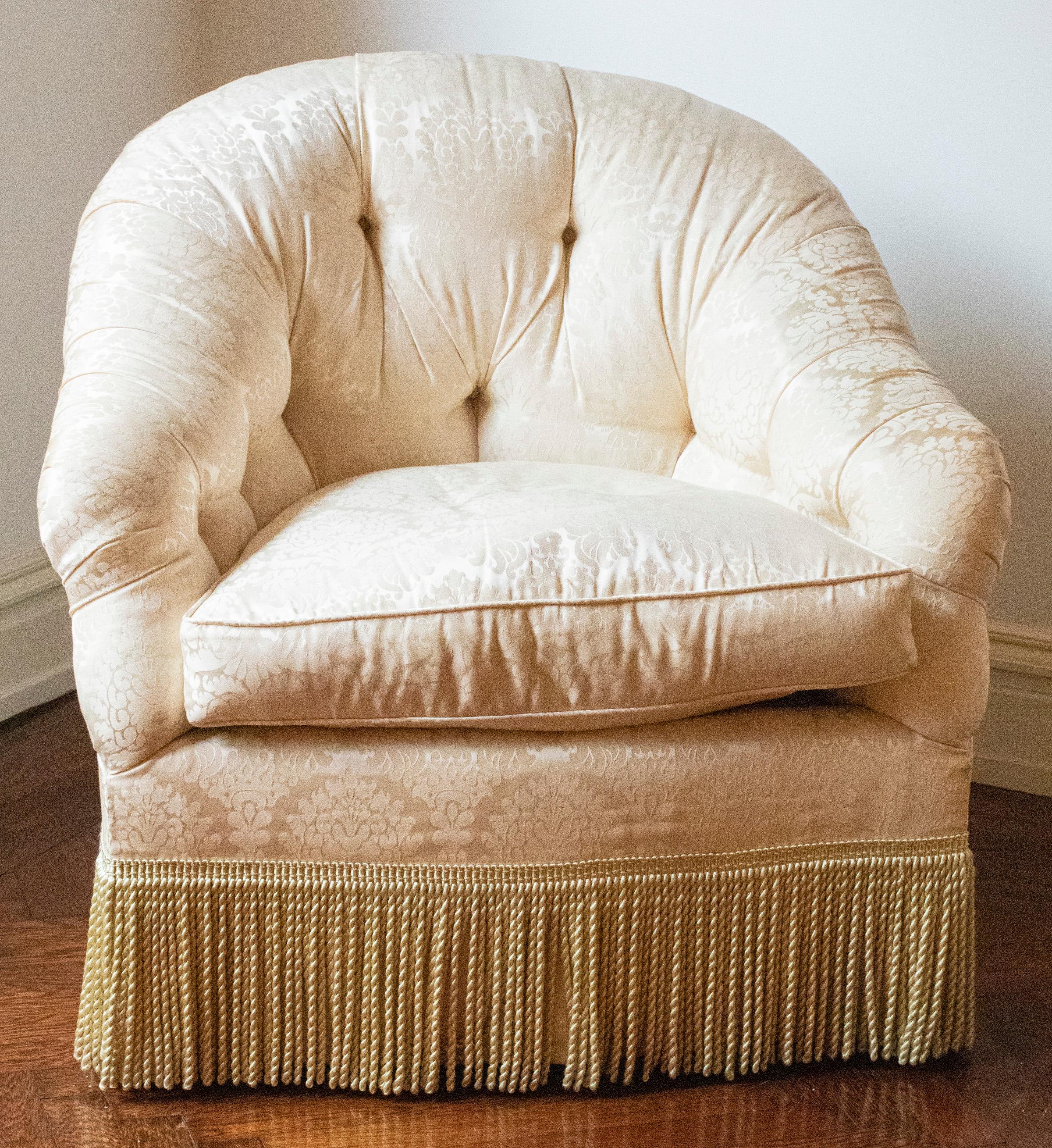 Pair of tub lounge chairs attributed to Howard & Sons London, damask pattern tufted upholstery, fringe at bottom. Measures: 33