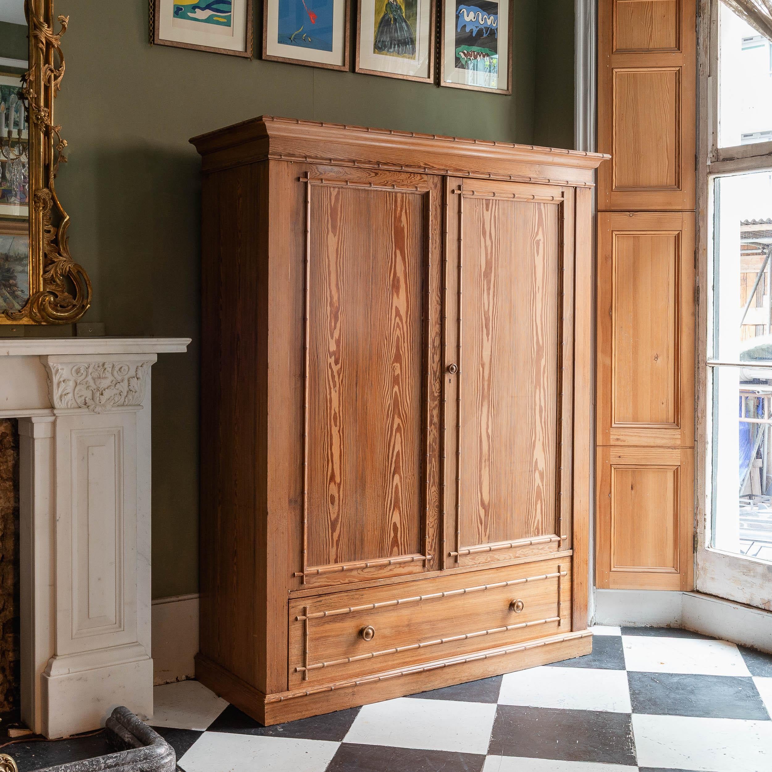 A splendid 'Howard & Sons' Douglas Fir wardrobe, stamped 'HOWARD & SONS BERNERS ST' and with paper label to the interior, late nineteenth century, with hanging rail and hooks fitted to the interior. Supports for interior shelving exist, these a