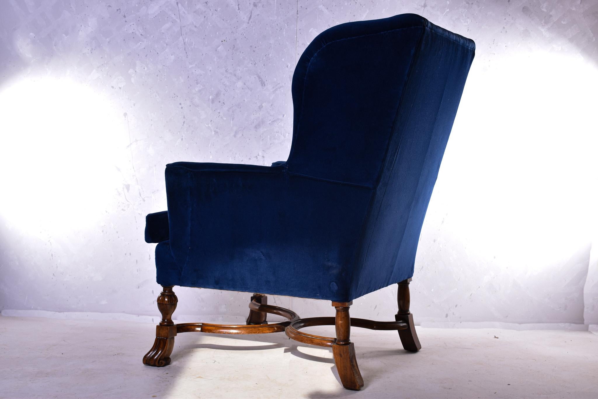 A rare and regal Howard and Sons wing back armchair in William and Mary style, C.1900.
Upholstered with blue plush fabric, on Braganza style front feet and with an 'X' stretcher, the
back left leg stamped '523011', the back right leg 'Howard &