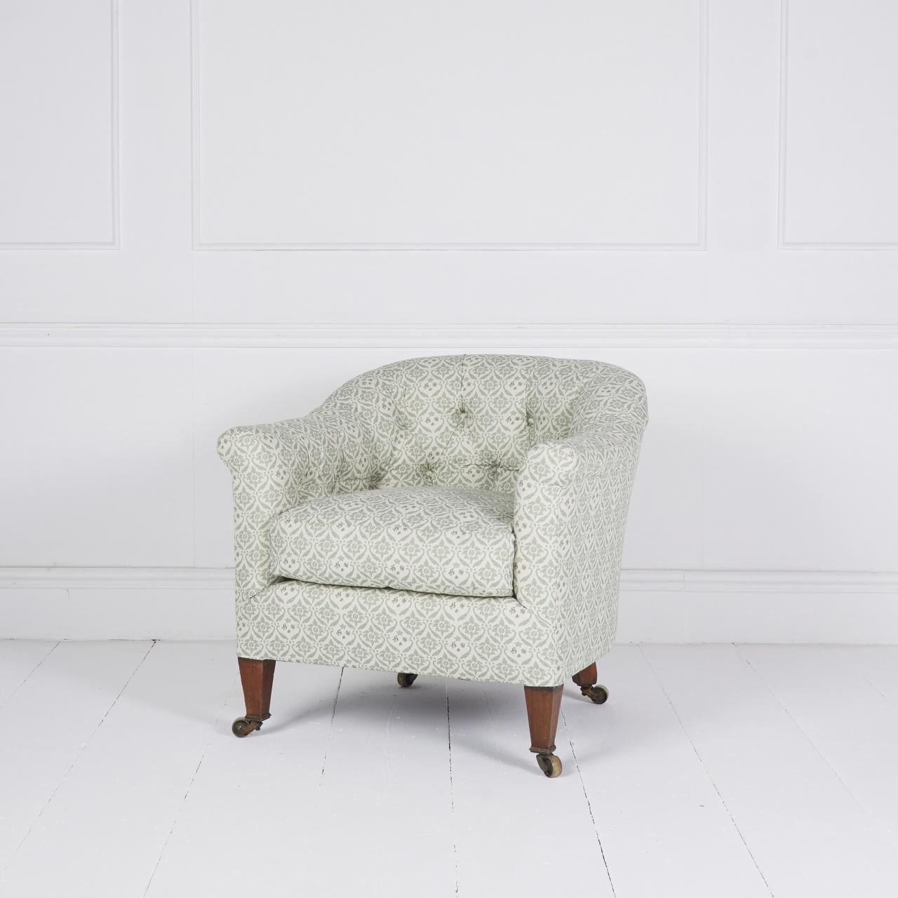 Confortable fauteuil baignoire édouardien recouvert de coutil H&S, reposant sur des pieds fuselés en acajou et des roulettes d'origine.

 à la manière de la régence d'Howard et de ses fils

Dimensions : H 30″  L 29″ D 30″

Angleterre Circa 1900

Ref