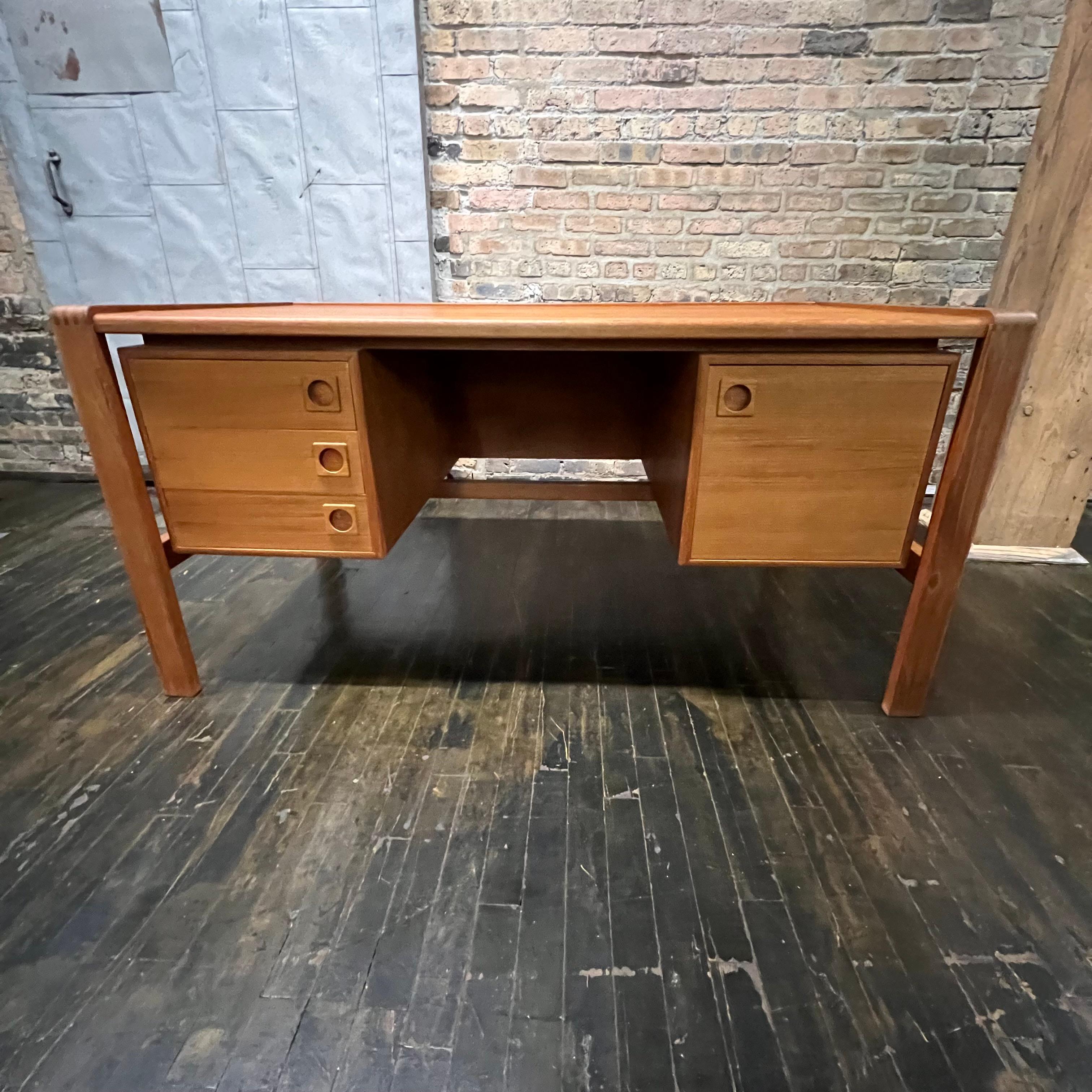 Mid-century executive floating top desk by H.P. Hansen manufactured in Demark circa 1970s. This beautiful desk was made of the highest quality teak.  The grain and color of the wood are outstanding.   It features three shallow dovetail drawers on
