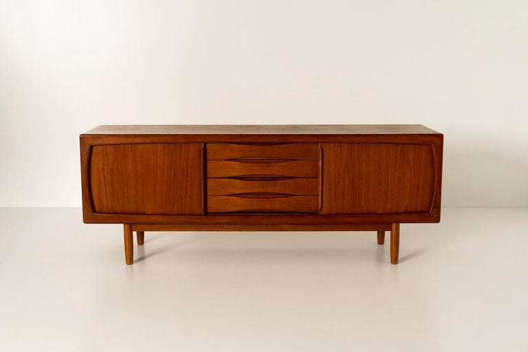 Lovely Scandinavian vintage sideboard in teak by H.P. Hansen from Denmark, the 1950s. Danish Mid-Century Modern design is identifiable by its minimalist aesthetic. It features four drawers and two sliding doors. It is supported by four rounded legs.