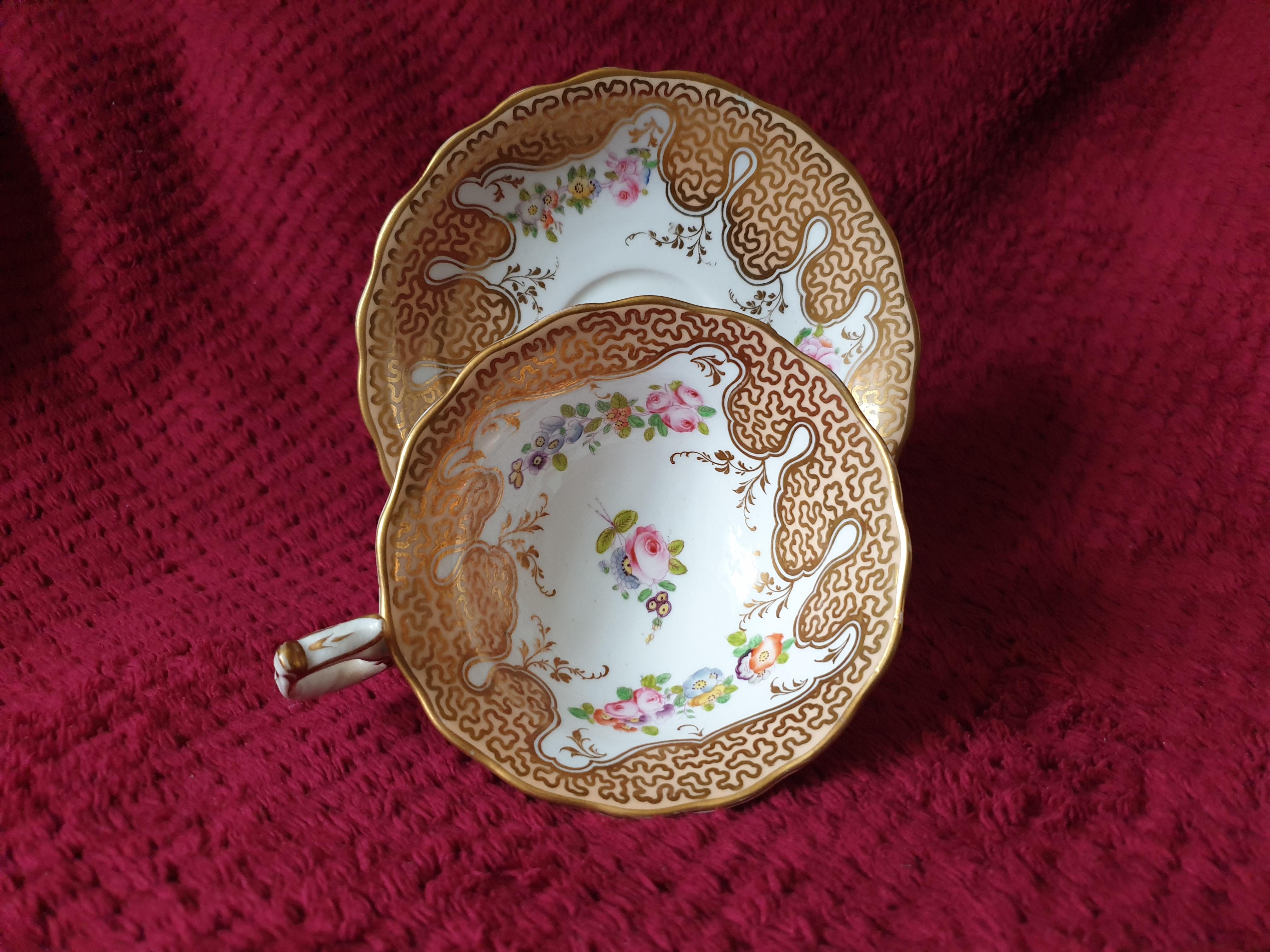 This delightful cup and saucer by H&R Daniel comes with an intricate scroll design on a peach ground. Beautiful summery flowers handpainted at the base  and around inside the cup and inbetween the scroll design on the saucer accentuate or give