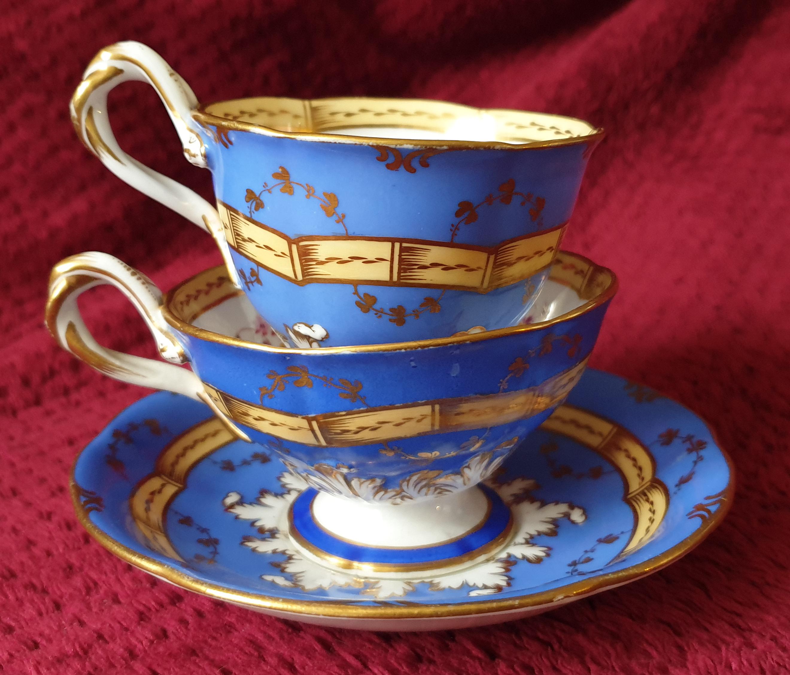 This stunning H&R Daniel twisted handle footed Trio is an antique of highest quality. It is a rare antique find! Handpainted with a beautiful sky blue ground, the trio consists of a coffee and teacuo and saucer. Their twisted handles and  footed