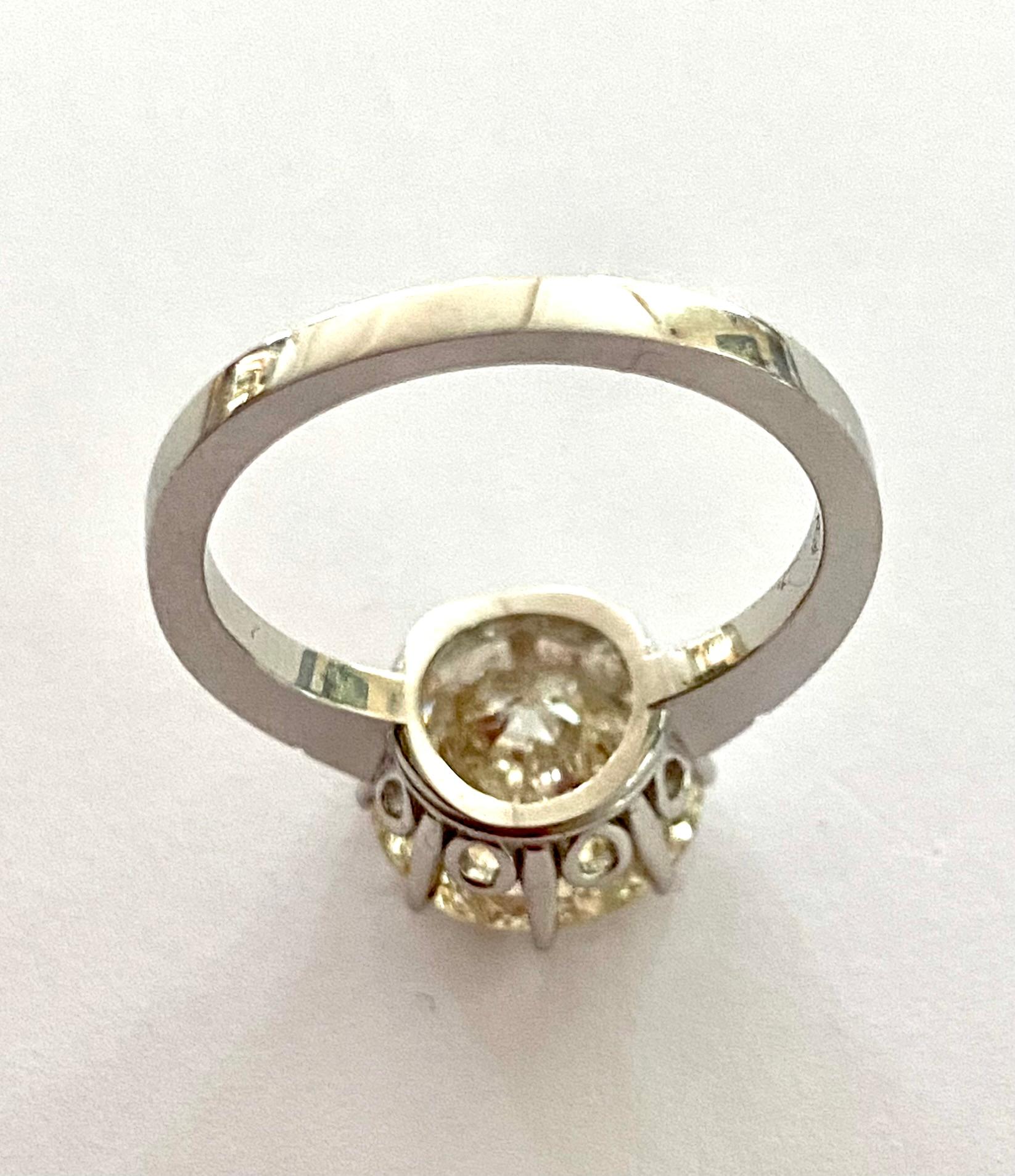 An 18K. white gold solitaire ring with a brilliant cut diamond of 5.56 ct.
Quality:   P2 (clear visible inclusion in the center of the stone)
color:      L = tinted white
Cut :       Old European cut.
-
the inclusion is easy to see, but the stone