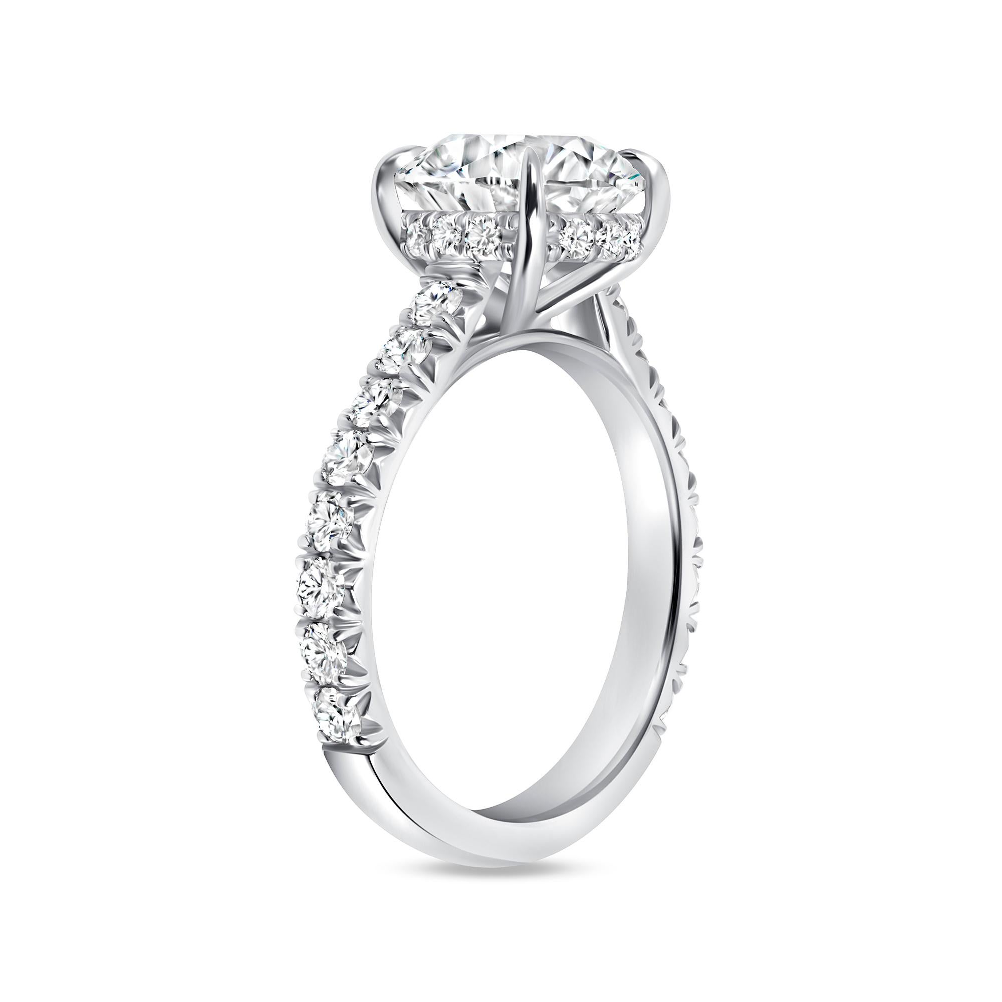 Anello con diamante tondo Brilliante e Halo nascosto con fascia Pavé in platino. L'anello Hiden Halo Diamond con fascia Pave ha come centro un diamante certificato HRD di colore H e di purezza SI2 di 3,03 carati e presenta ventotto diamanti rotondi
