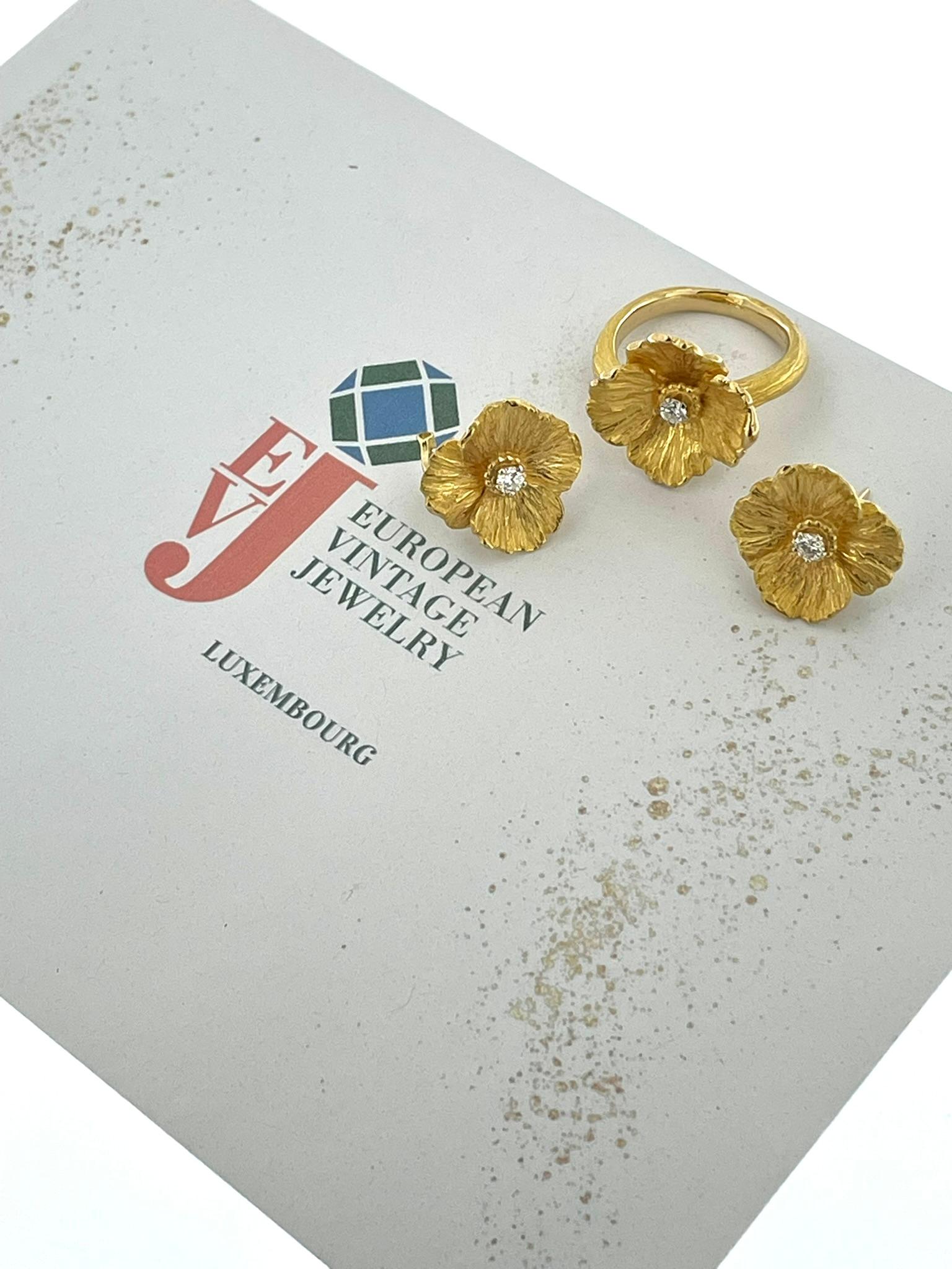 Dieses HRD-zertifizierte Blumenset aus Gelbgold mit Ring und Ohrringen ist ein exquisites Schmuckstück, das Eleganz und Charme ausstrahlt. Sowohl der Ring als auch die Ohrringe sind mit viel Liebe zum Detail gefertigt und zeigen ein atemberaubendes