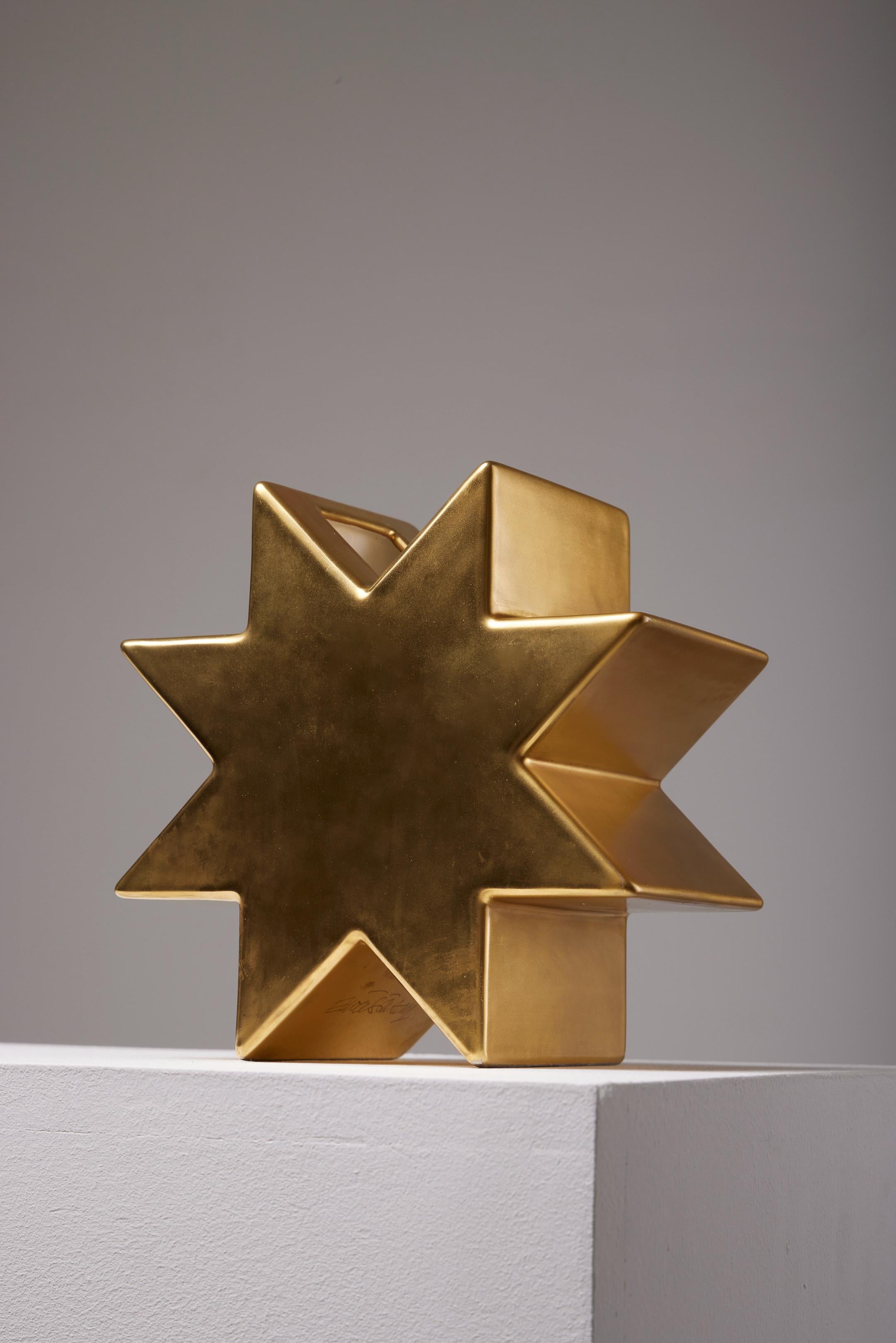 Golden vase model 'Hsing' by designer Ettore Sottsass, 1980s. Ettore Sottsass collaborated in the 1970s with Alessi, Baccarat, and Knoll, creating everyday objects for them. This star-shaped vase is made entirely of gold-colored glazed earthenware.