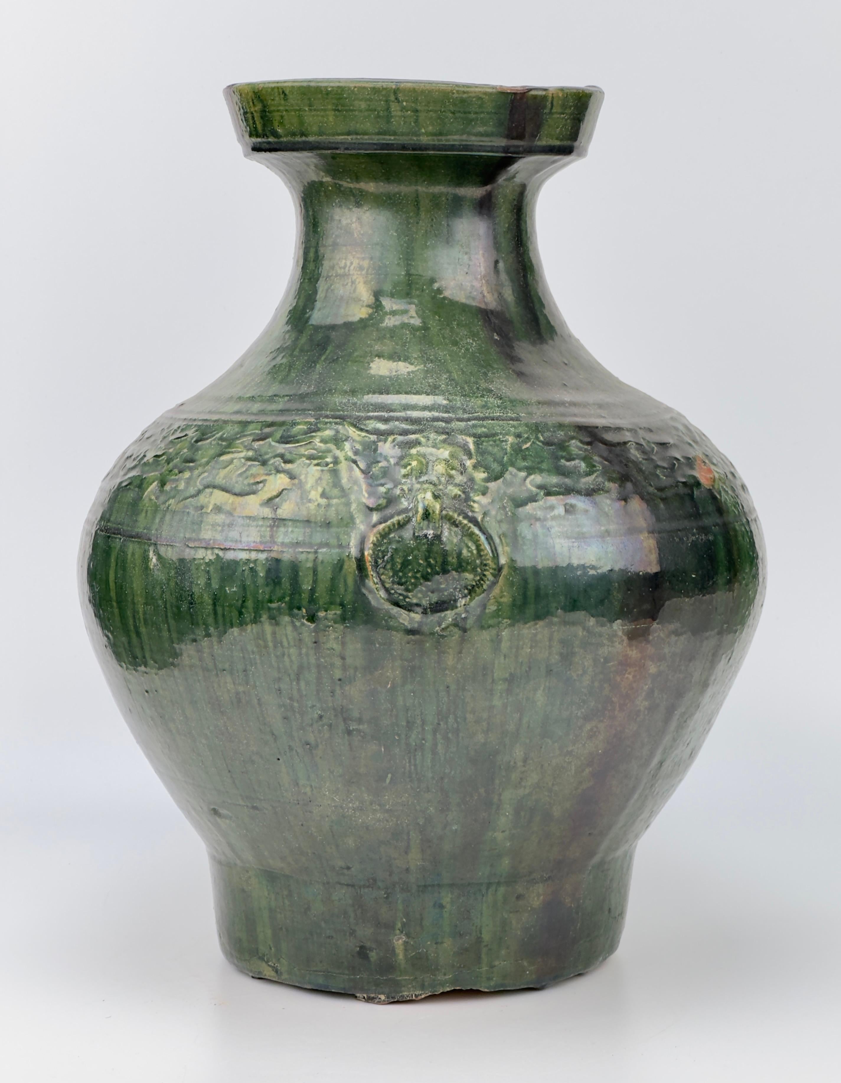 It is made from a fairly high-fired reddish pottery and coated in a particularly attractive glossy thick streaky green and finely-crackled glaze, the colour of which varies according to its thickness. 