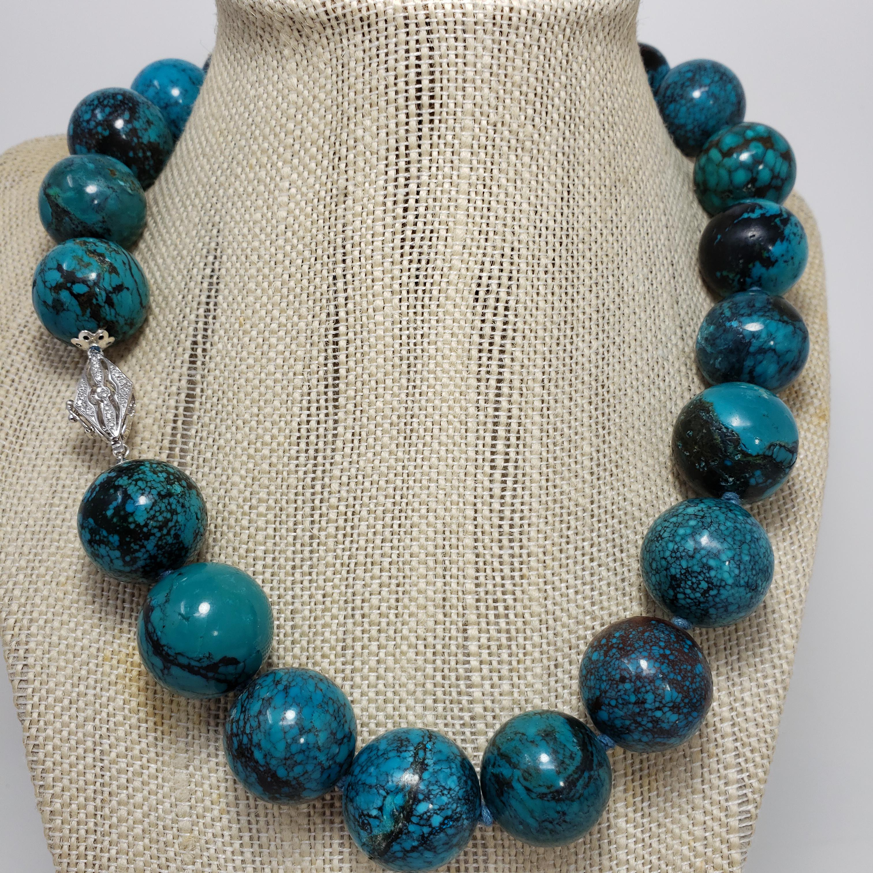 An exquisite Hubei turquoise bead necklace featuring a single strand of 20mm turquoise beads in gorgeous teal, green, and earth tones. Fastened with a 14K white gold diamond-encrusted clasp. Gorgeous turquoise tones for a bold look!

Hallmarks: 585