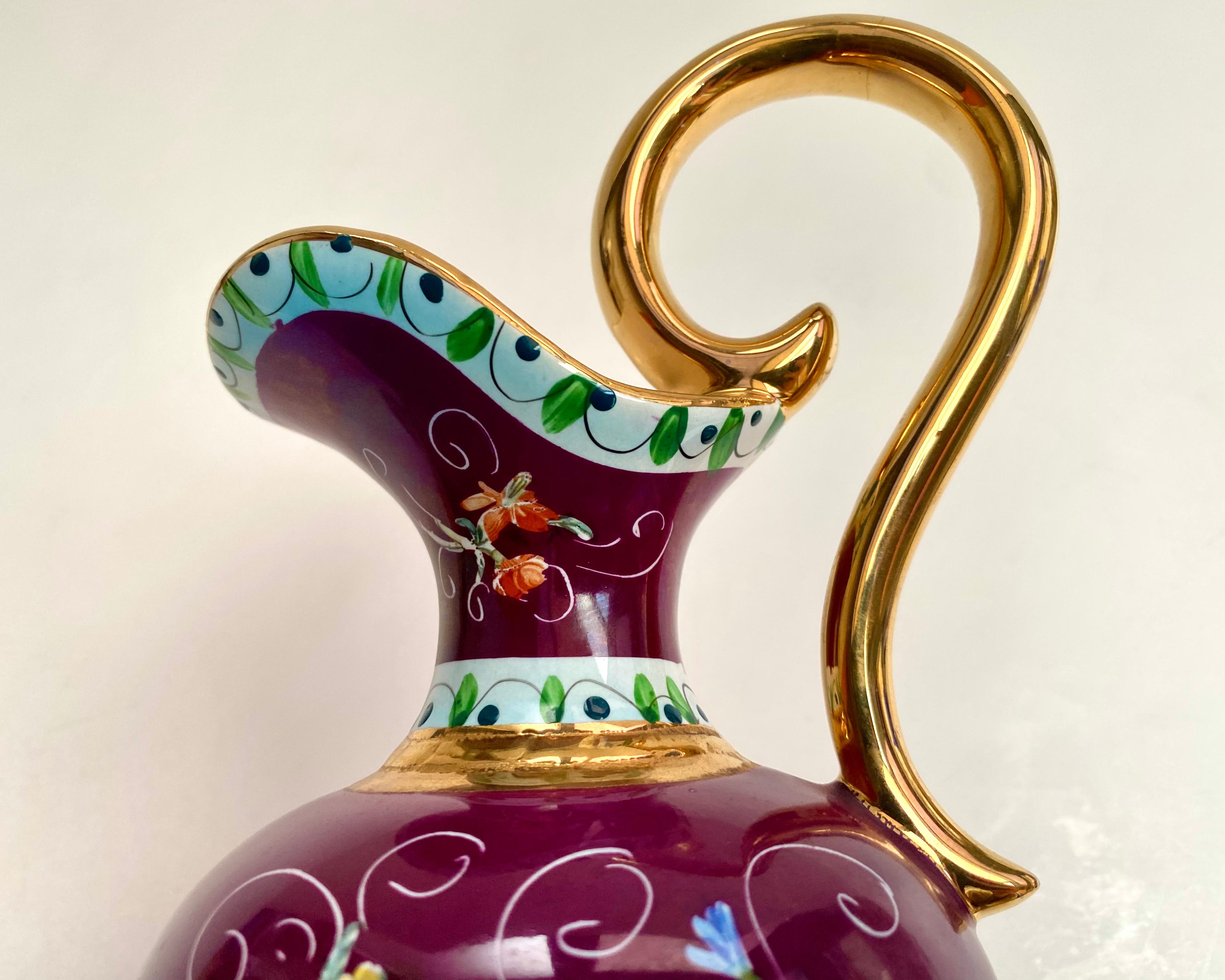 Gorgeous Hubert Bequet ceramic pitcher vase with a beautifull burgundy background decorated with a bright colorful raised enamel pattern of a colorful flowers.

Belgium, 1970s

All hand crafted and hand painted. All accents in gold including the