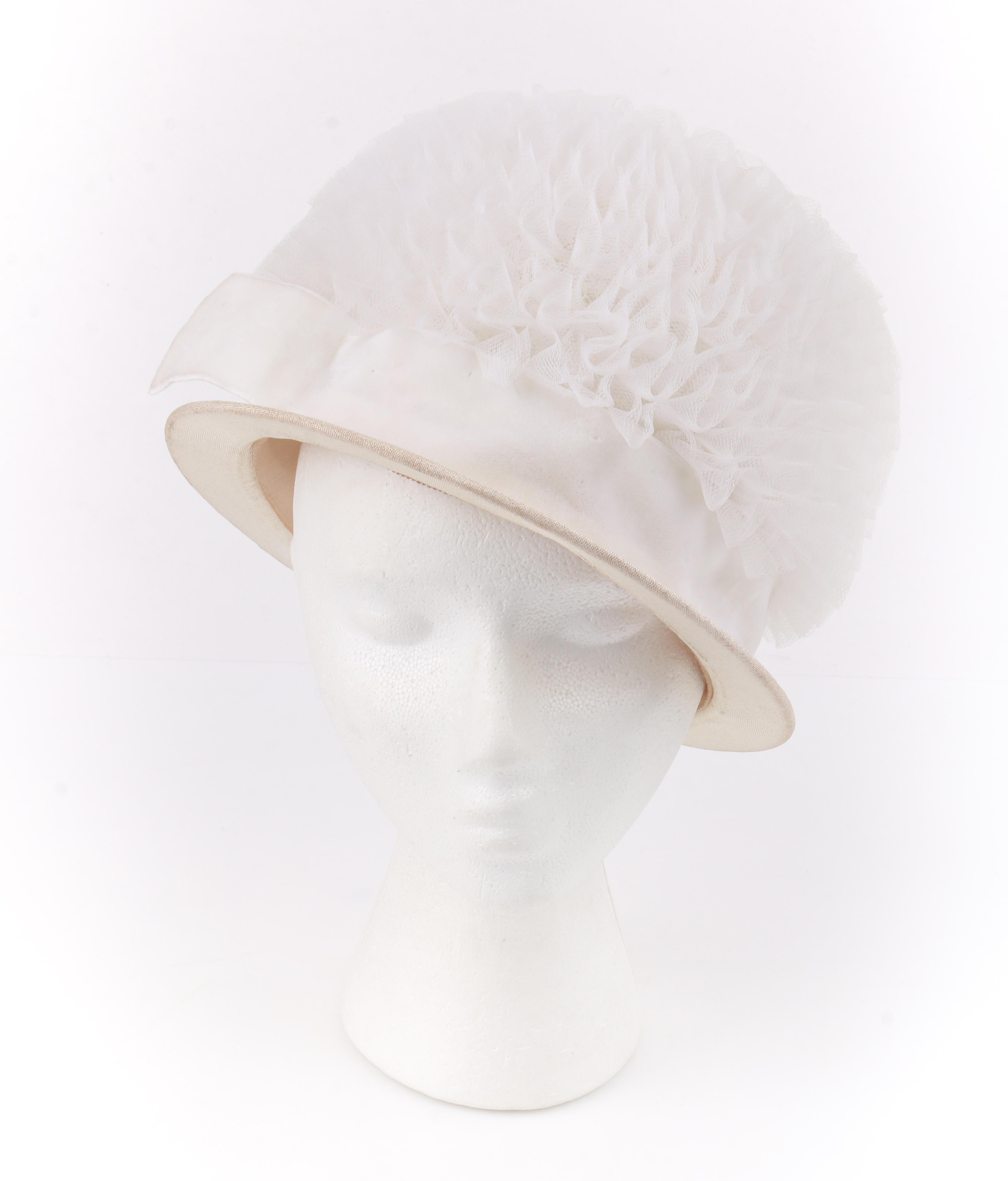 HUBERT DE GIVENCHY ADAPTION c.1950's Gathered Tulle Velvet Ribbon Cloche Hat

Circa: 1950’s 
Label(s): Hubert de Givenchy; Union label
Style: Cloche Hat
Color(s): Shades of white / cream
Lined: No
Unmarked Fabric Content: Tulle (exterior); velvet