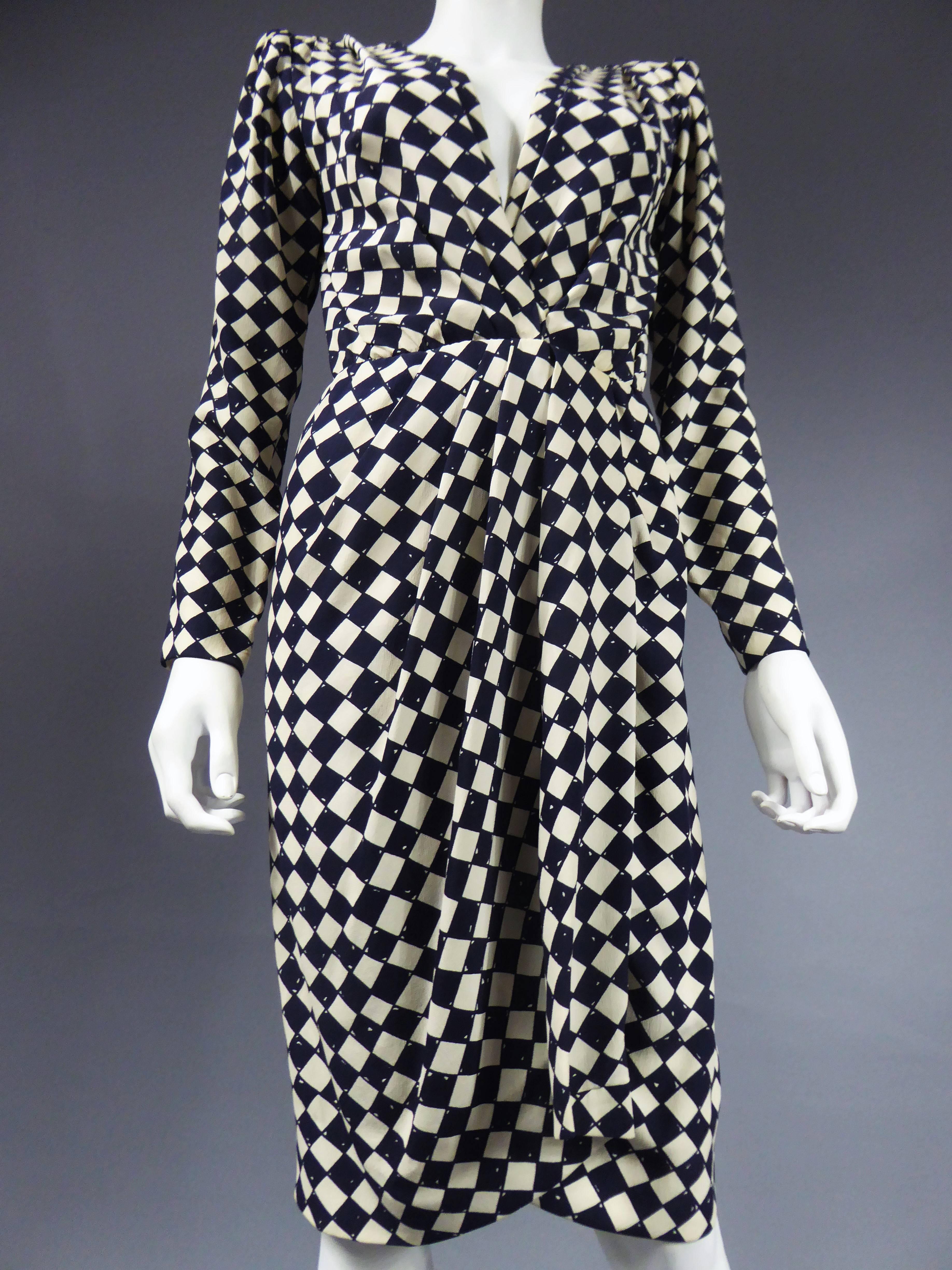 Circa 1980
France
Hubert de Givenchy dress Haute Couture Numbered 77304. Silk crepe with graphic harlequin print in black and white. Long sleeves and midi wrap skirt. Large integrated shoulder pads. Integrated zipper under the wallet of the skirt,