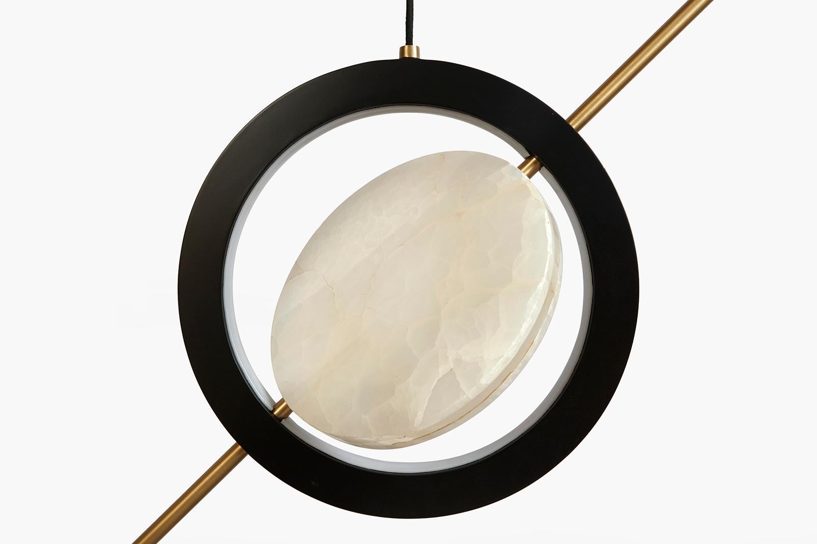 The “Hubert Pendant” with its simplistic form and composition is elevated through its material choice and the highlight of their characteristics. Two concentric circles of light are centered by a translucent slab of onyx that can be positioned by