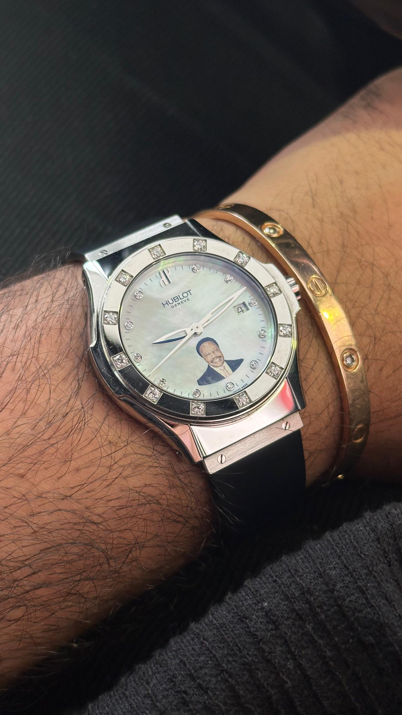Presentamos el reloj Hublot Classic Fusion Unisex Edición Limitada Presidente Ali Omar Bongo, con una elegante caja plateada y un bisel liso engastado con doce diamantes redondos talla brillante. 

El reloj tiene una preciosa esfera de nácar con