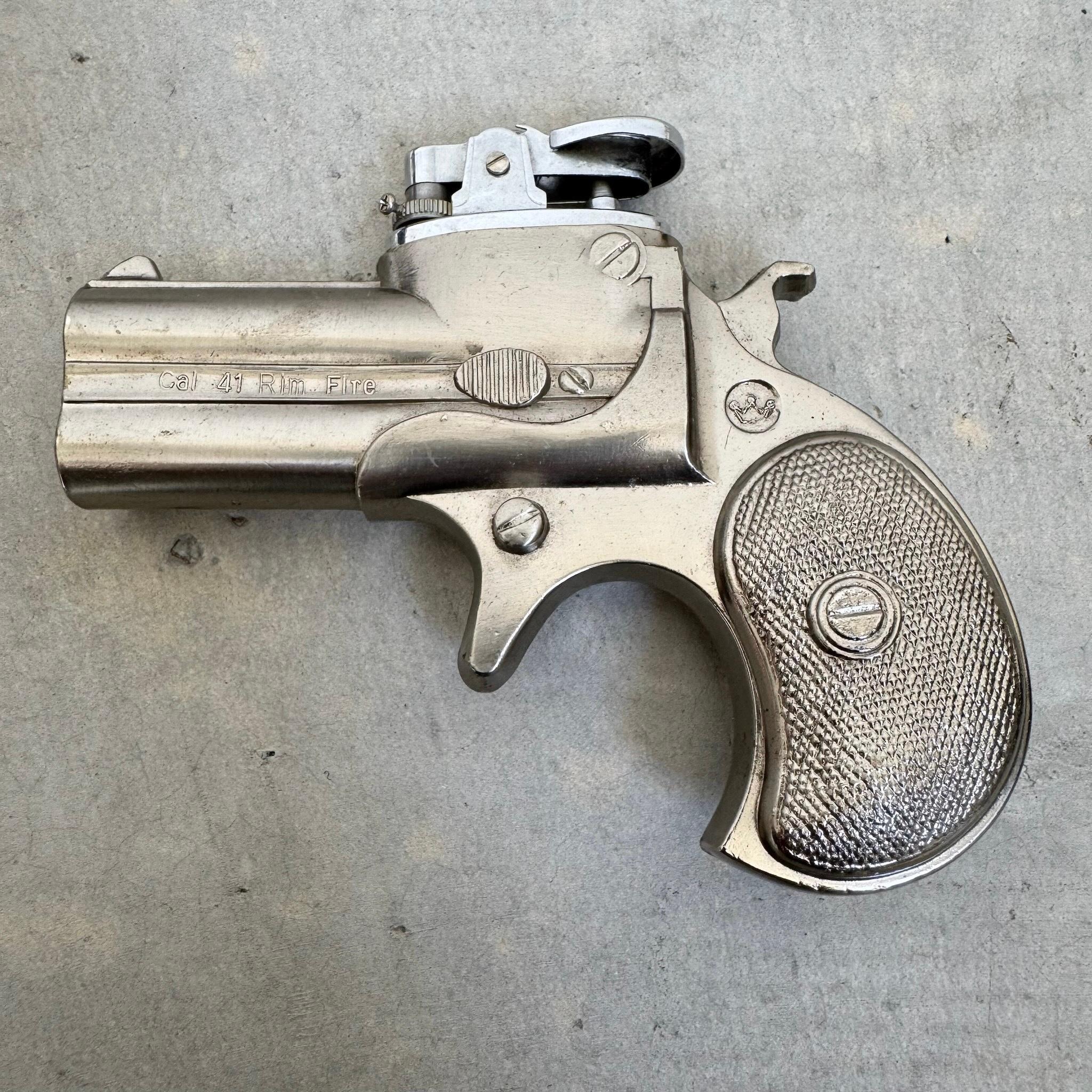 This handsome lighter is cast in the shape of a double barrel derringer. Perfect for any collector of smoking paraphernalia or firearm enthusiast. Meticulous attention to detail throughout makes for a compelling tribute to its source material. The