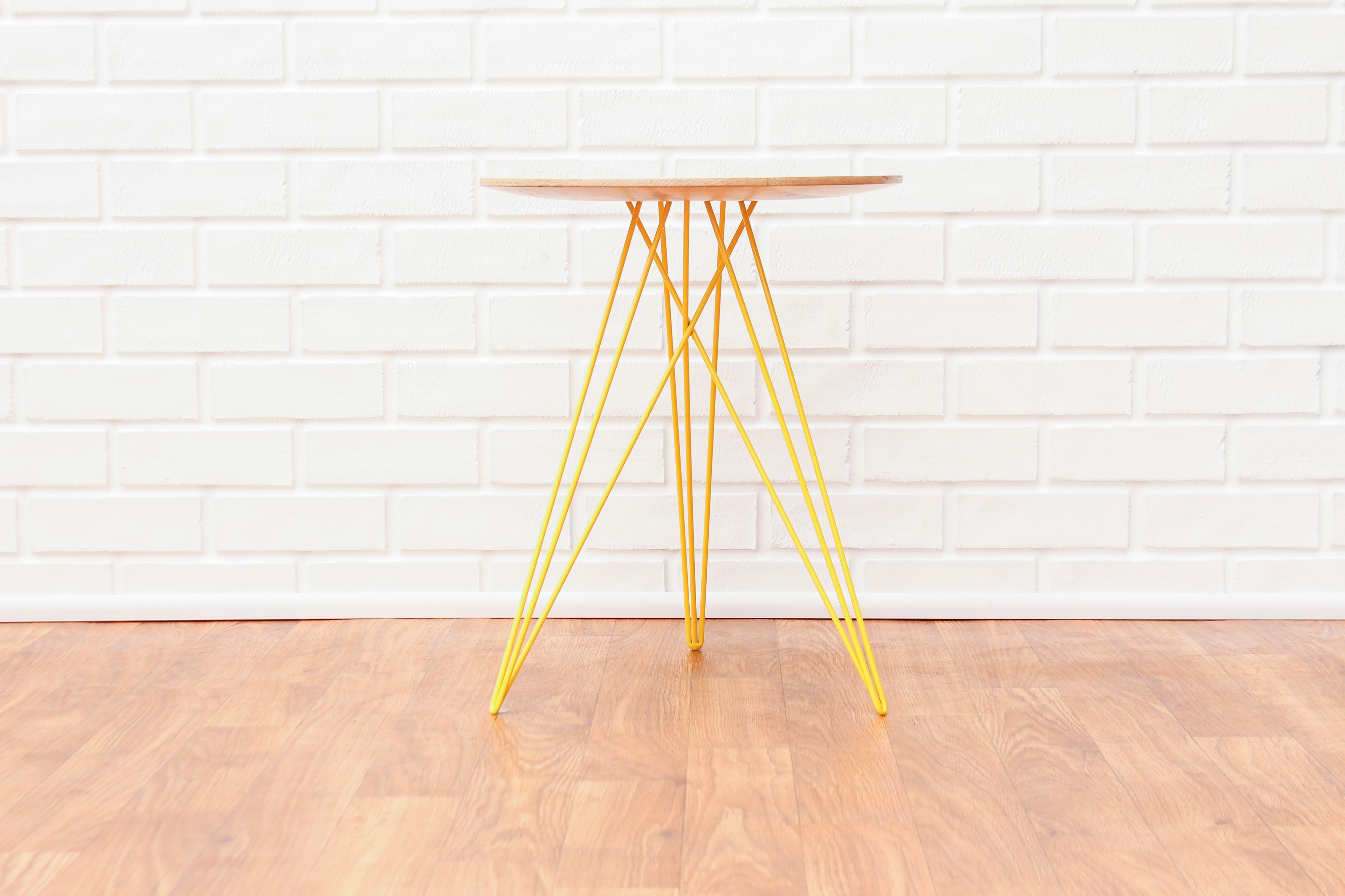 This eye-catching piece combines an industrial structure with sophisticated modern accents. The intersecting metal legs almost seem to play tricks on the eyes and change shape as you circle around the table. It is finished with a slim and elegantly