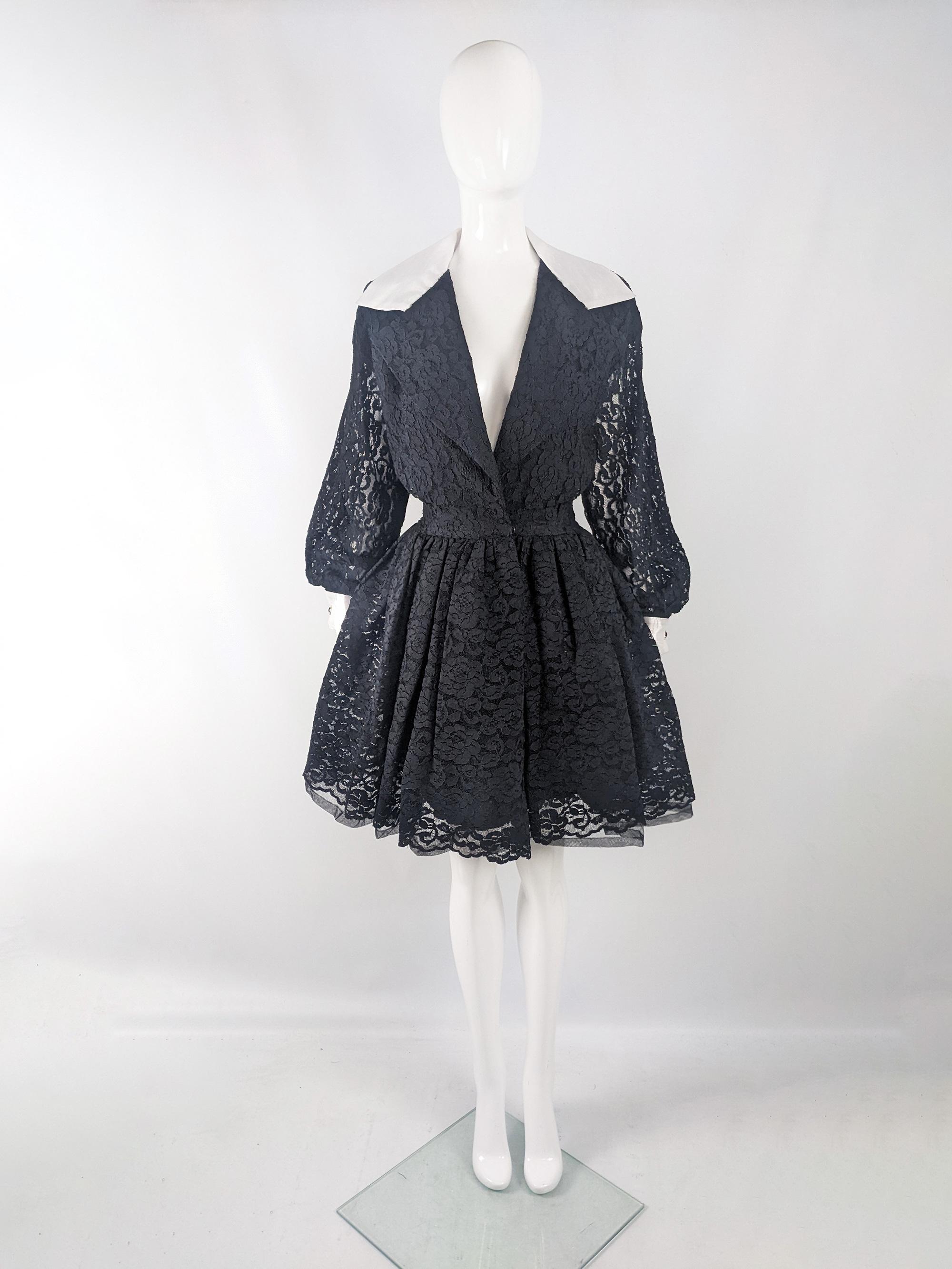 A glamorous vintage womens dress from the 80s by luxury American designer, Huey Waltzer. In a black lace with sheer bishop sleeves, a deep neck and a fantastic silhouette that is slightly loose and blouson on the bust, with a nipped waist and a