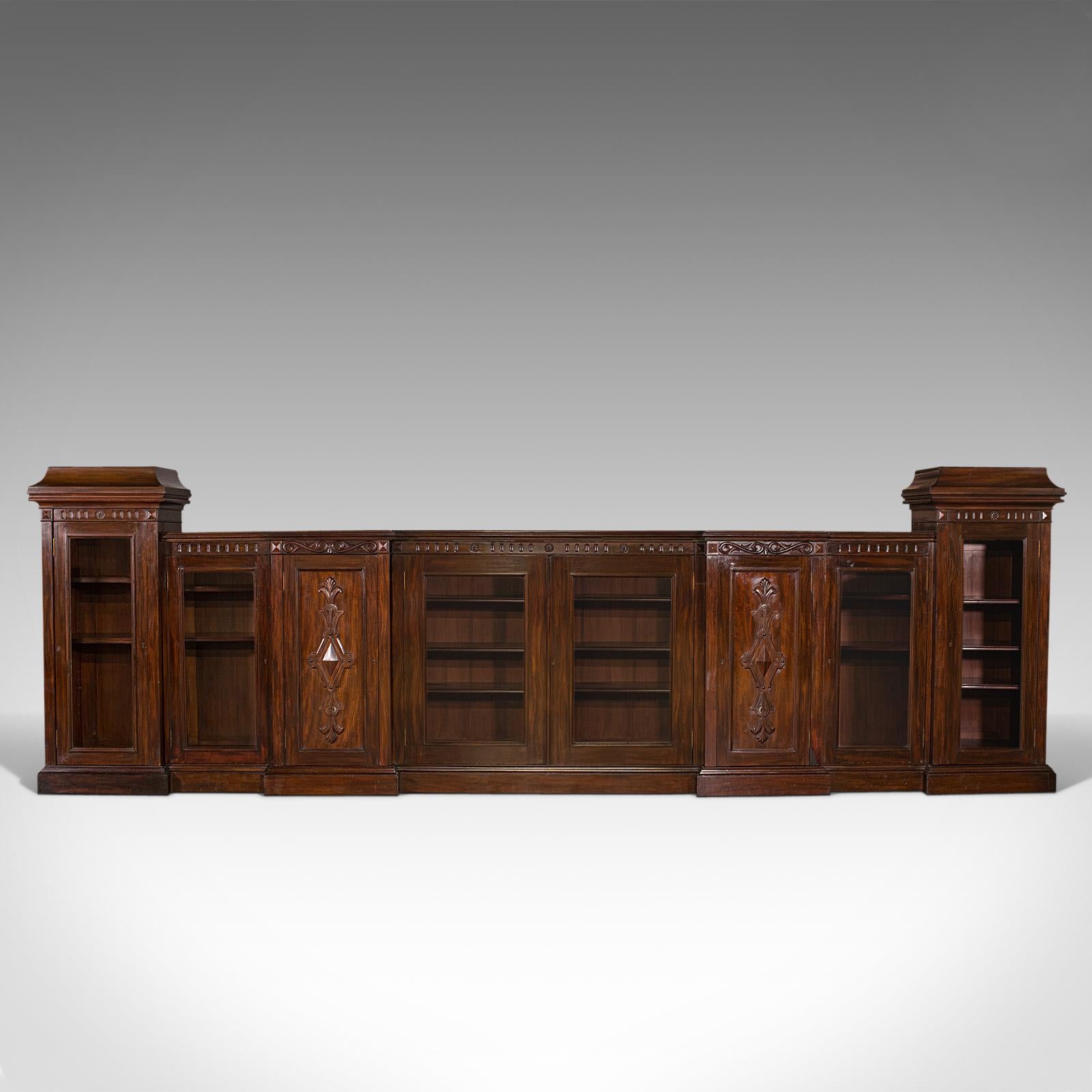 This is a very large antique glazed bookcase. An English, mahogany breakfront library cabinet, dating to the Victorian period, circa 1880.

Truly arresting proportion at a width of 15 feet
Displaying a desirable aged patina throughout
Select