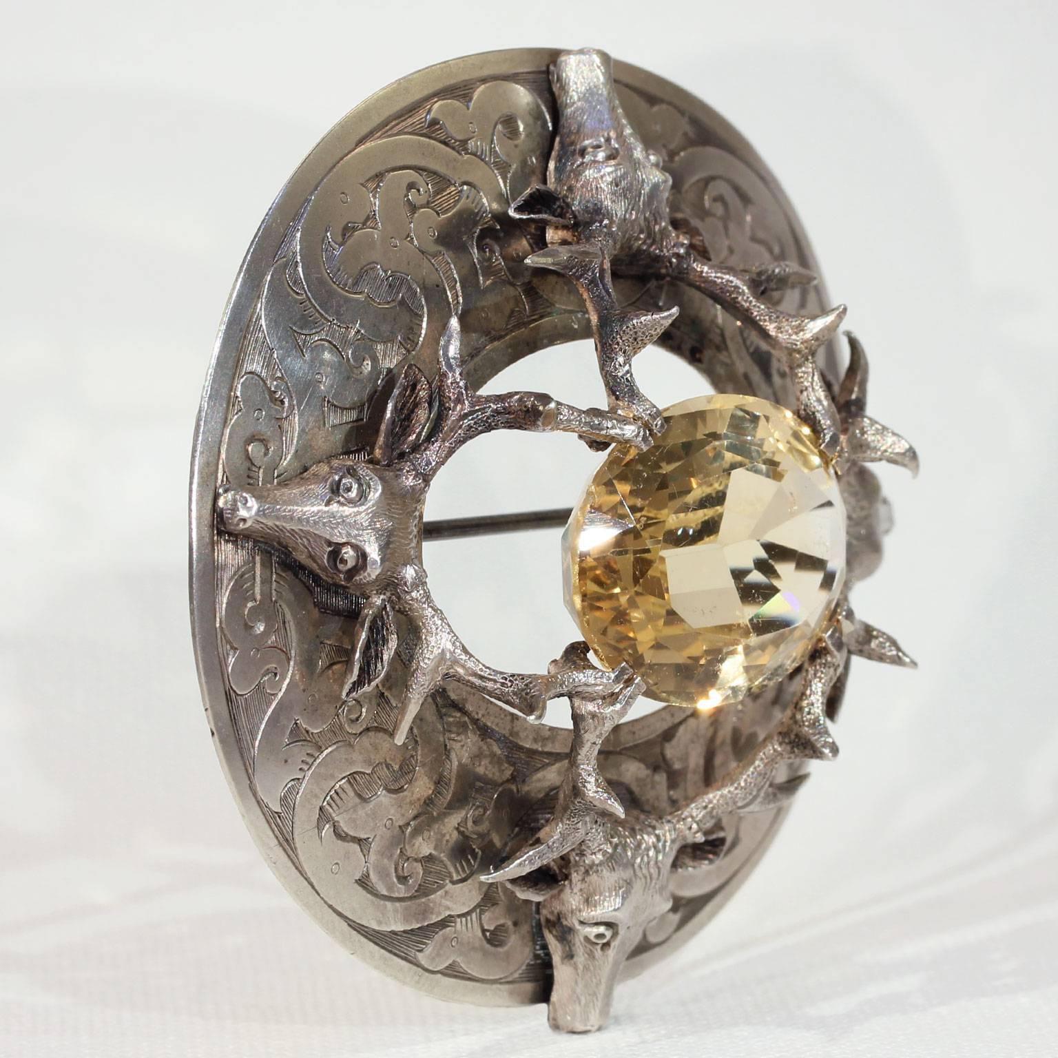 This awesome and very large antique Victorian citrine silver brooch was handcrafted around 1850-60 in Scotland. It features a quadruple deer head motif with the antlers holding the oval faceted citrine in place. This stone measures 27.4 x 19.3 x