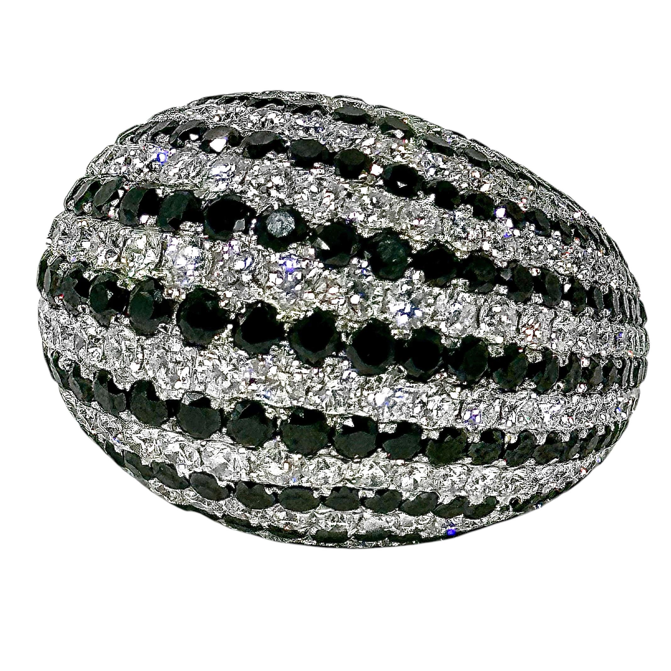 This huge, high quality 18K white gold, dome ring is set with rows of alternating white and black modern brilliant cut diamonds. Eleven rows of black diamonds alternate with ten rows of white diamonds, creating stripes. The bold contrast makes this