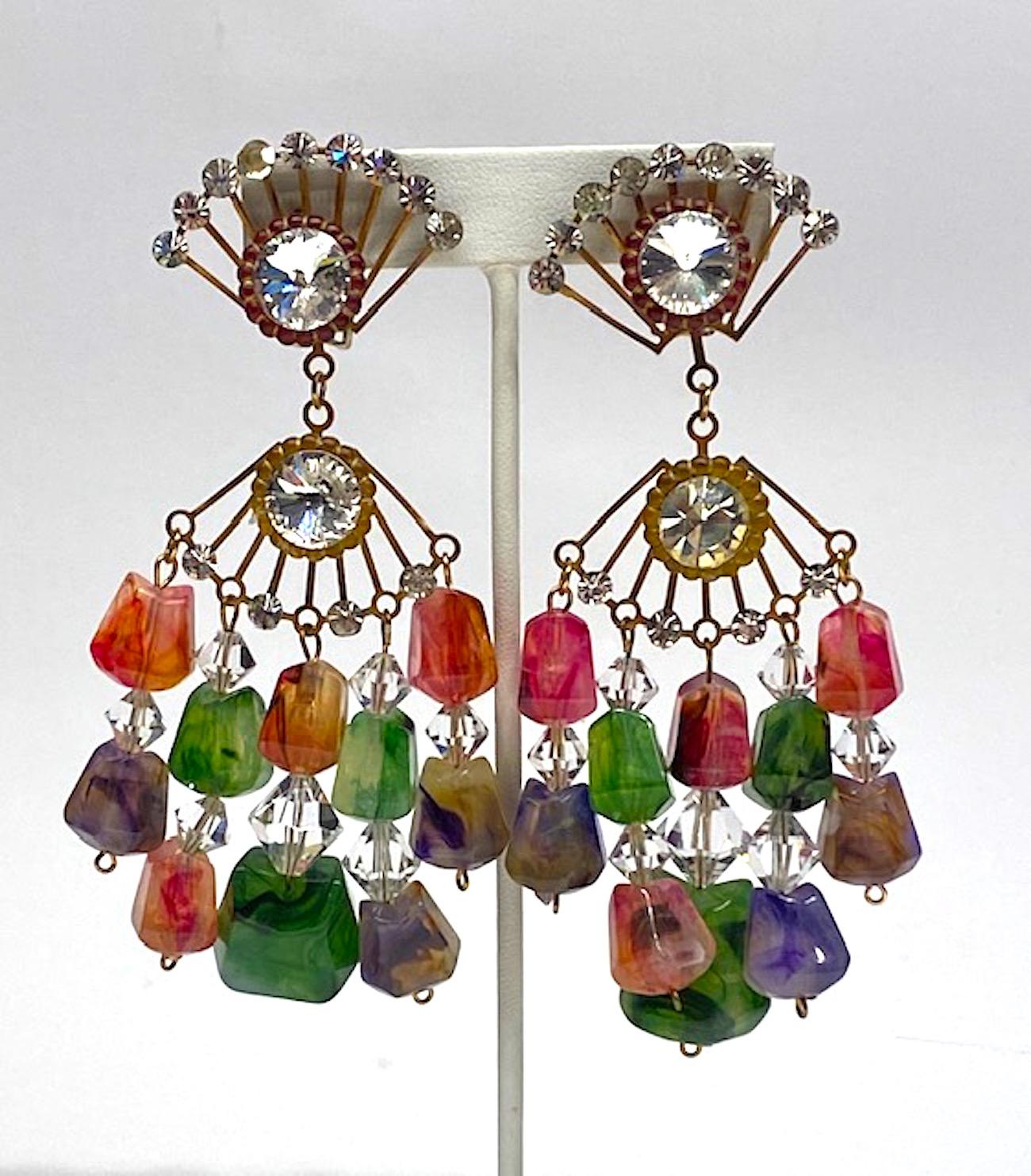 A true vintage and statement pair of chandelier earrings from the early 1970s. Each earring is comprised of two 1.5 wide by 1 inch high fan shape antique brass patina findings. Each set with small round rhinestones and one large rivoli rhinestone.