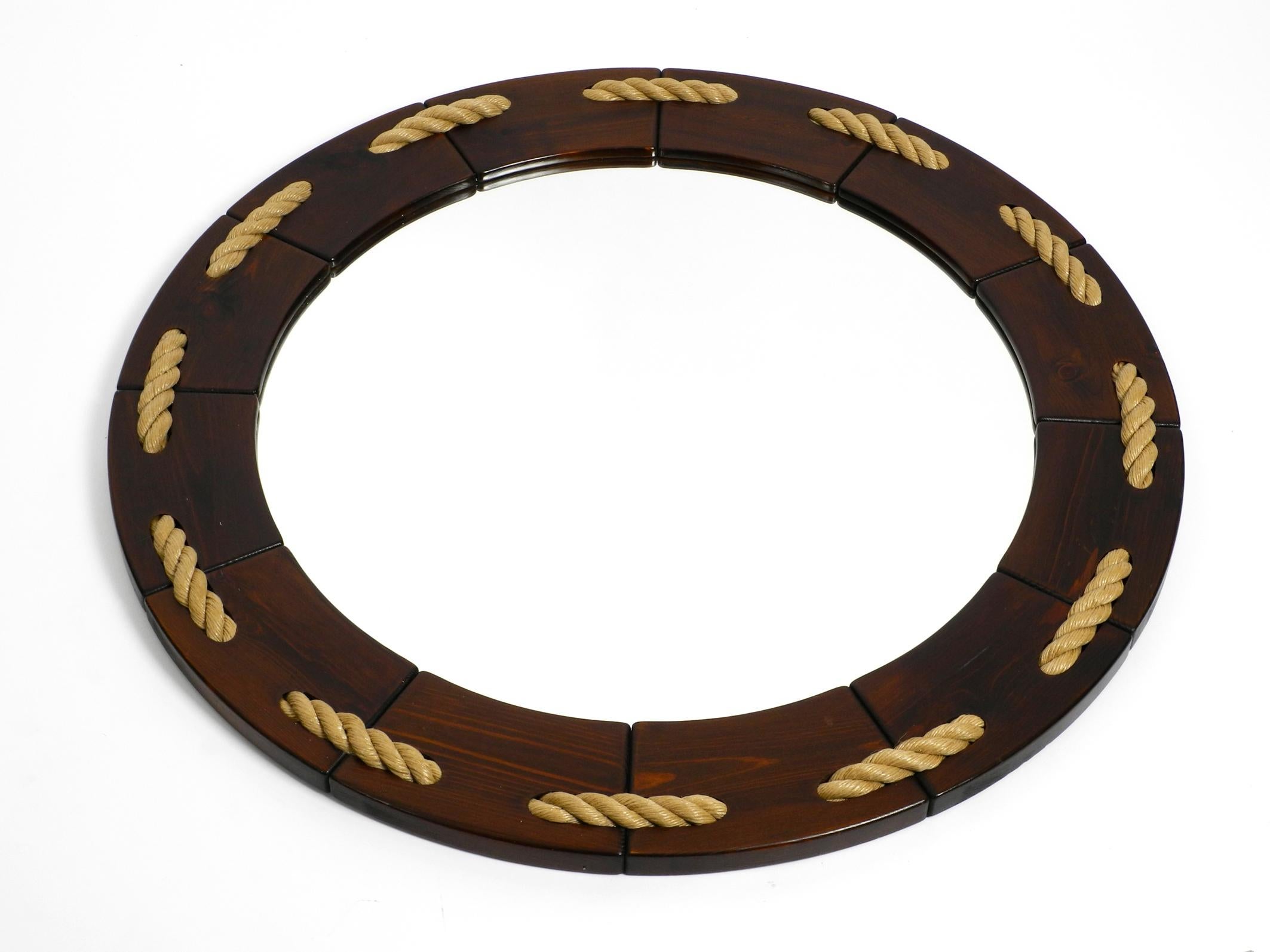 Huge 1970s maritime round pine wood wall mirror from Denmark.
Great minimalistic design in reddish brown with great pine grain.
Frame consists of several parts, held together by a thick braided sisal rope.
Gives the whole look a maritime style.