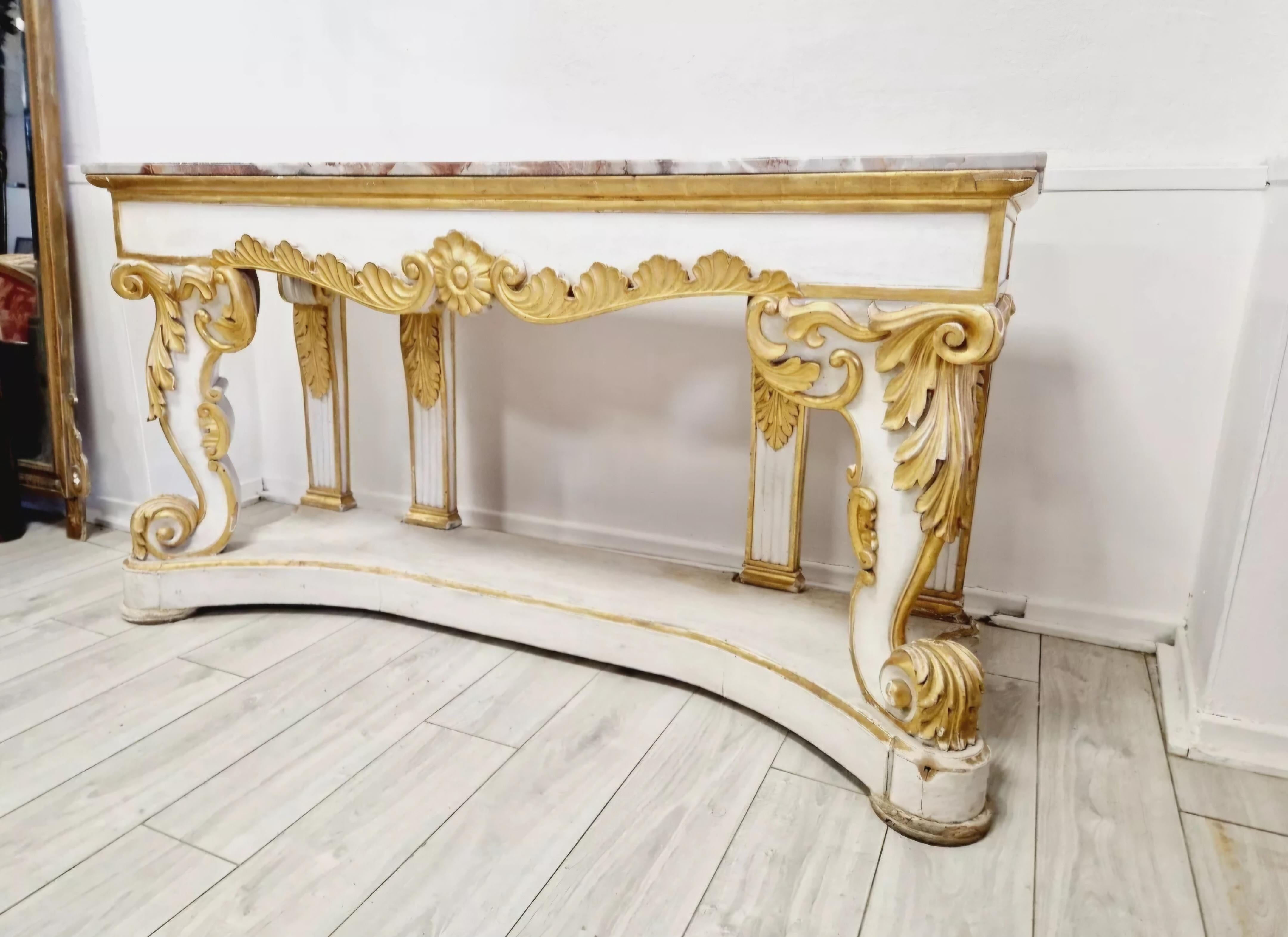 This Huge Antique Baroque Console Table with a stunning Marble Top is a magnificent piece of furniture that will complement any room. The table is fully assembled, made of solid wood, and features beautiful carvings and a base shelf. The imposing